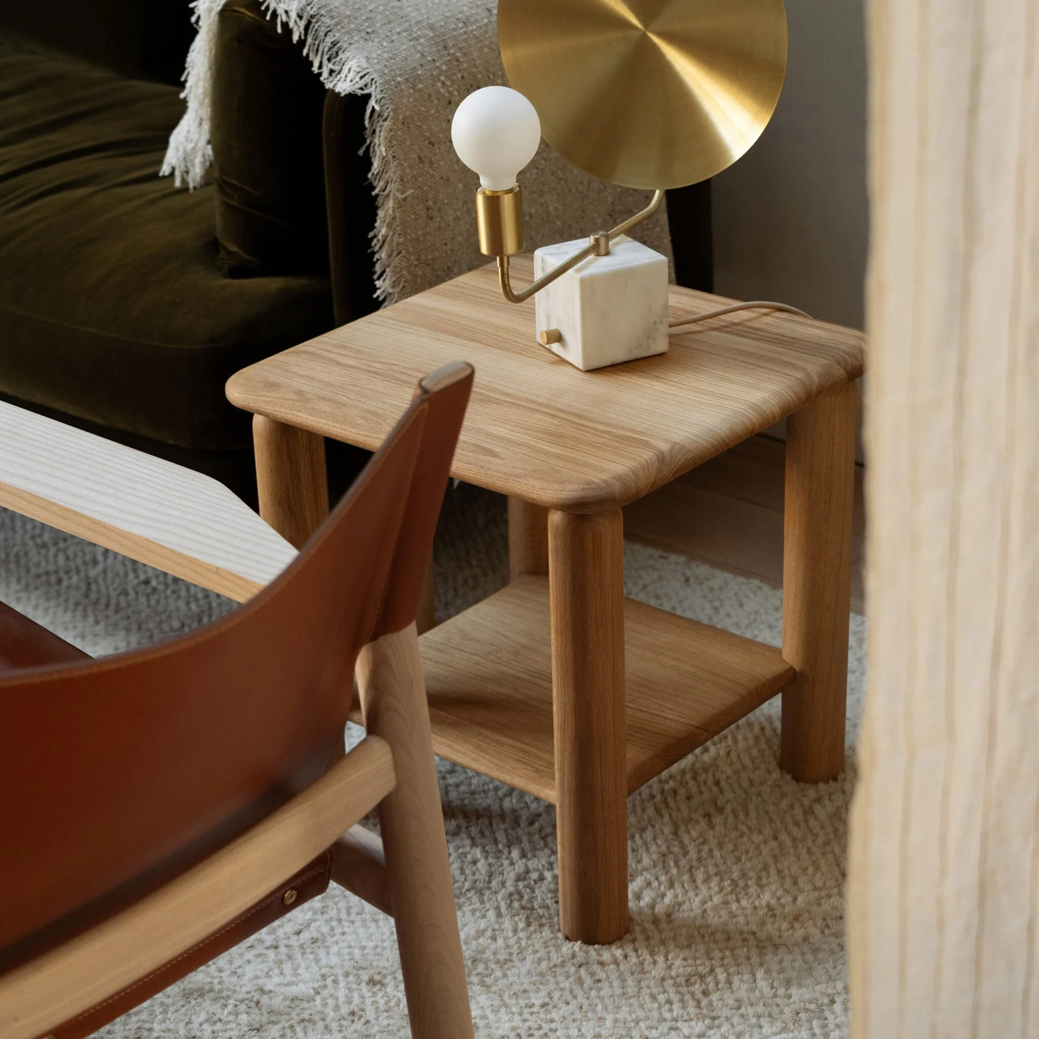 Feld Side Table beside an armchair in a cosy contemporary living room