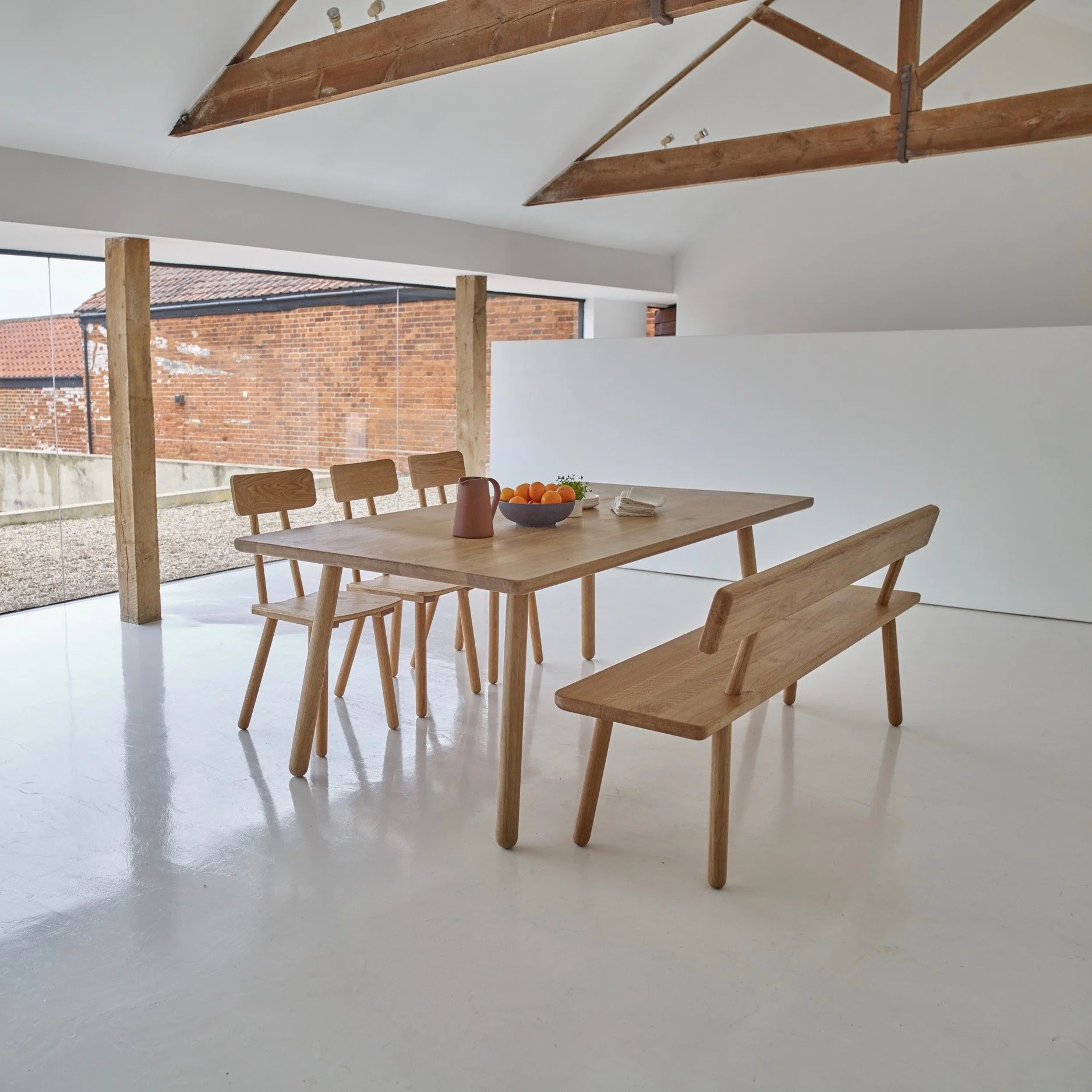 Dining Table ONE by Another Country in a light flooded dining room