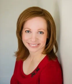 Photo of Jillian David in red shirt smiling at camera
