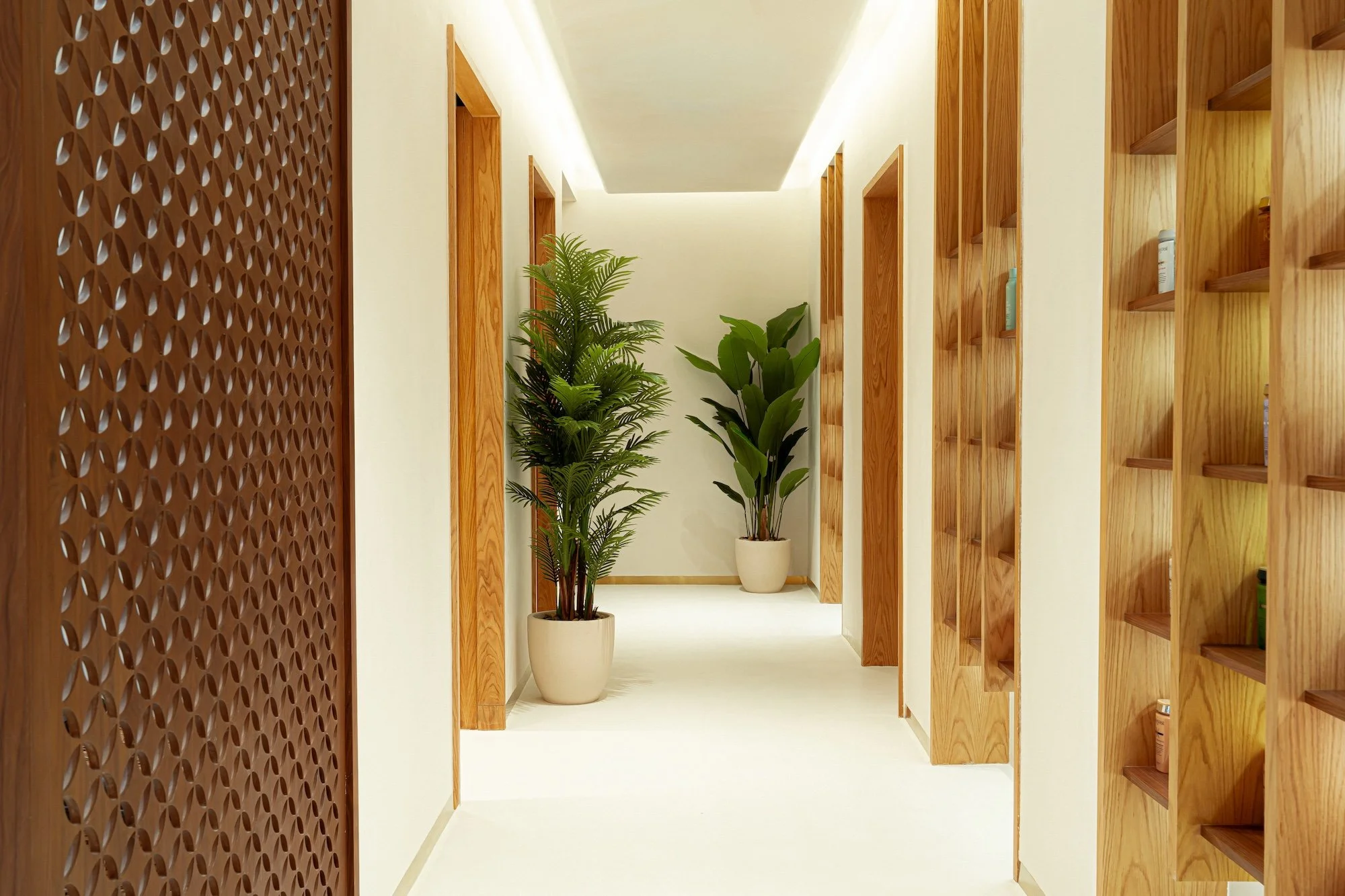 A softly lit corridor leading to private treatment rooms at Vera Wellness.