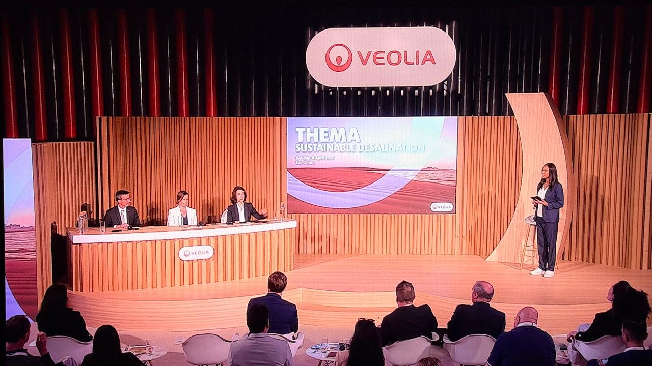 The completed stage during THEMA: Sustainable Desalination, showing the panel setup, presentation screen, Veolia branding and audience environment delivered from the original design.