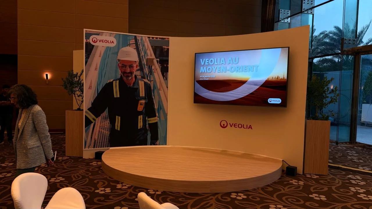 A branded presentation area created for Veolia Au Moyen-Orient, combining digital content, corporate imagery and a raised platform within the event environment.