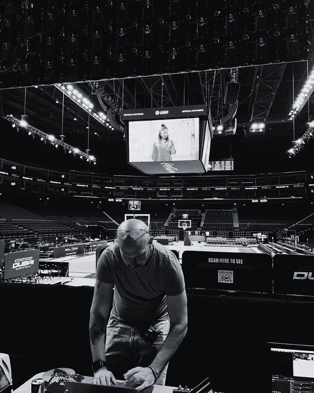 Dan Clark reviewing the running order and show content from the courtside production position before a Dubai Basketball game.