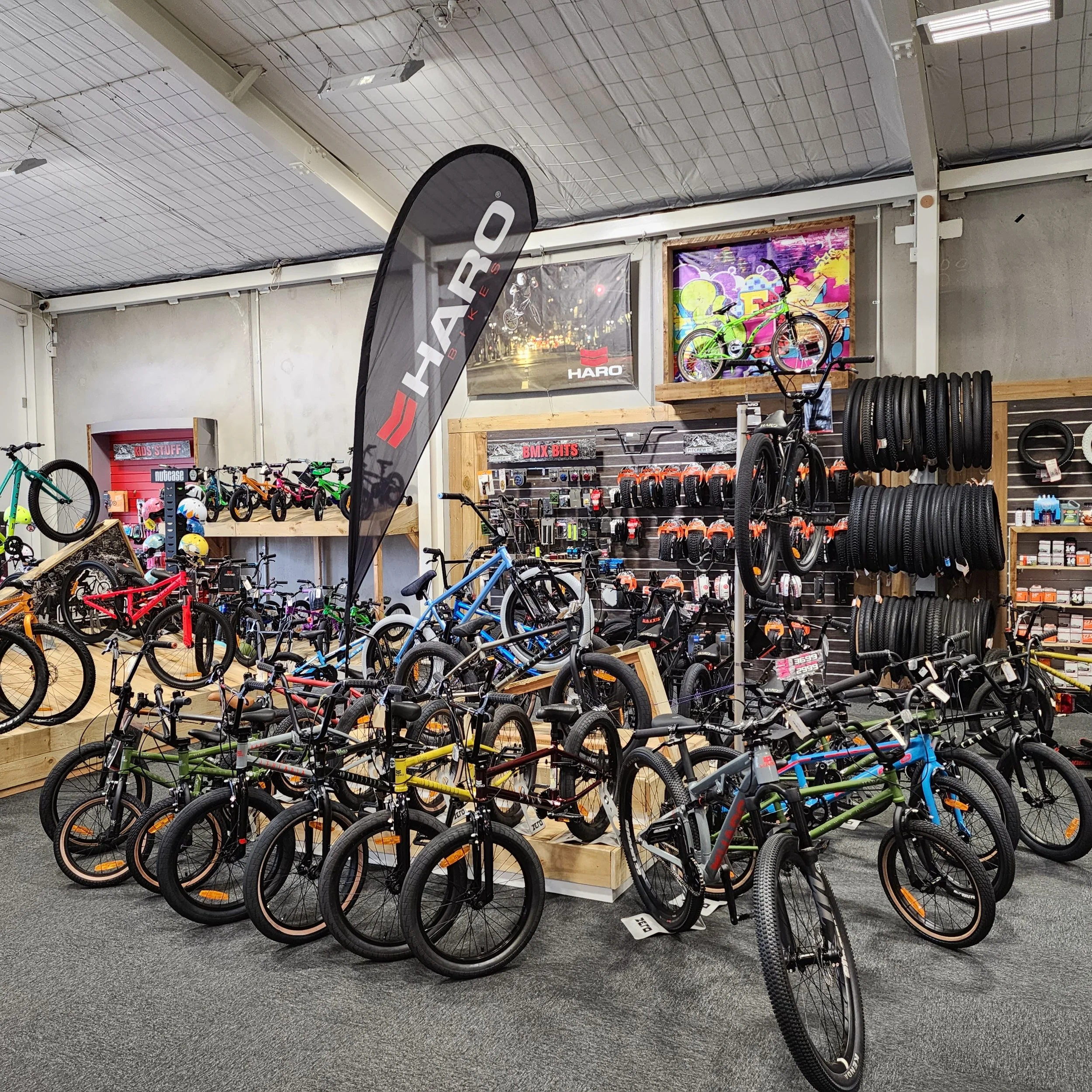 Indoor bicycle shop displaying various bikes, tires, and accessories with a black HRAP banner.