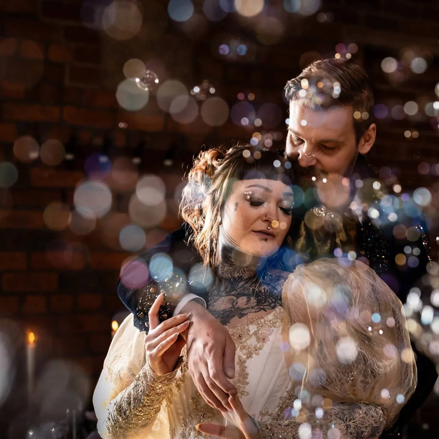 thereal wedding couple surrounded by bubbles and soft light — alternative bridal makeup by Sira Rose UK