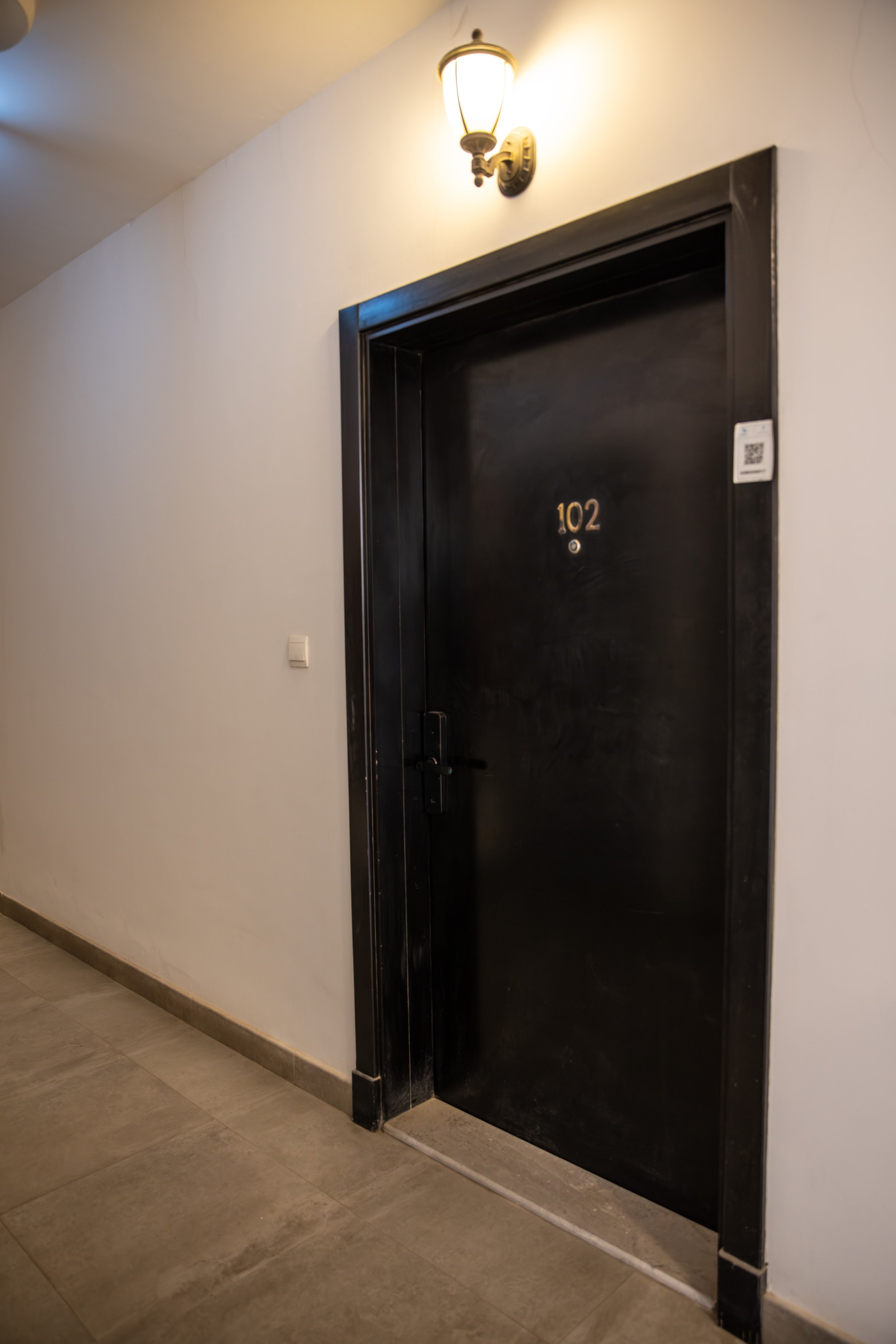 Hotel room entrance with a sign that reads "Cancun Suite Vip 03", showing a glimpse of a modern, well-decorated lounge area inside.