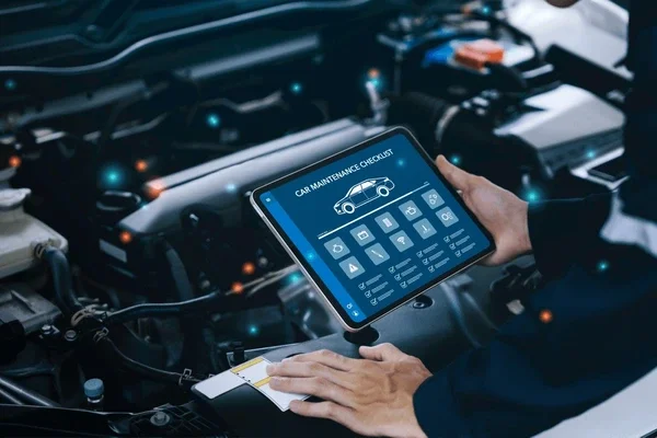 Person using tablet with a car maintenance checklist in a car engine bay.