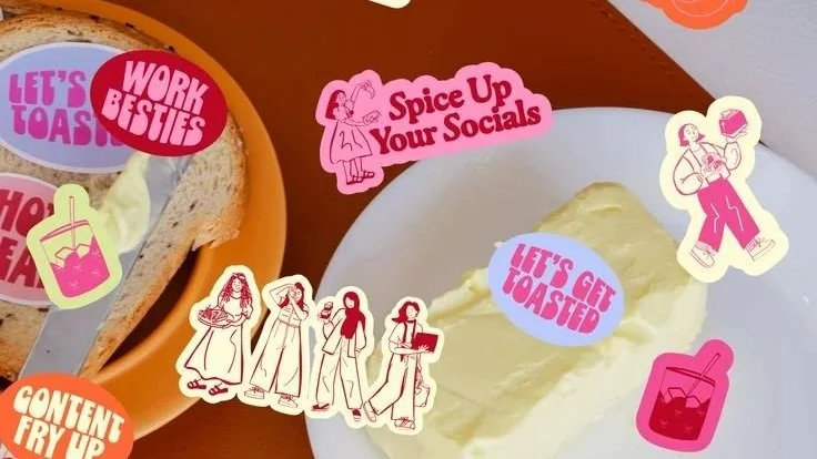 Decorative stickers on food items and table featuring phrases like 'Let's Get Toasted,' 'Work Besties,' and 'Spice Up Your Socials' with images of toast, drinks, and women in various poses.