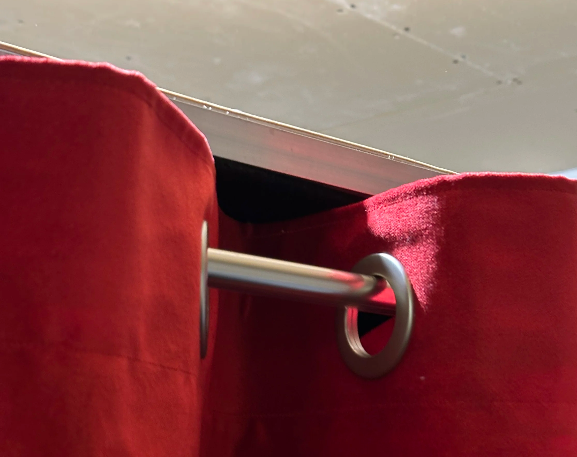 Punainen kankainen kangas ja metalliruuvi, osittain näkyvä pöytä tai taso.