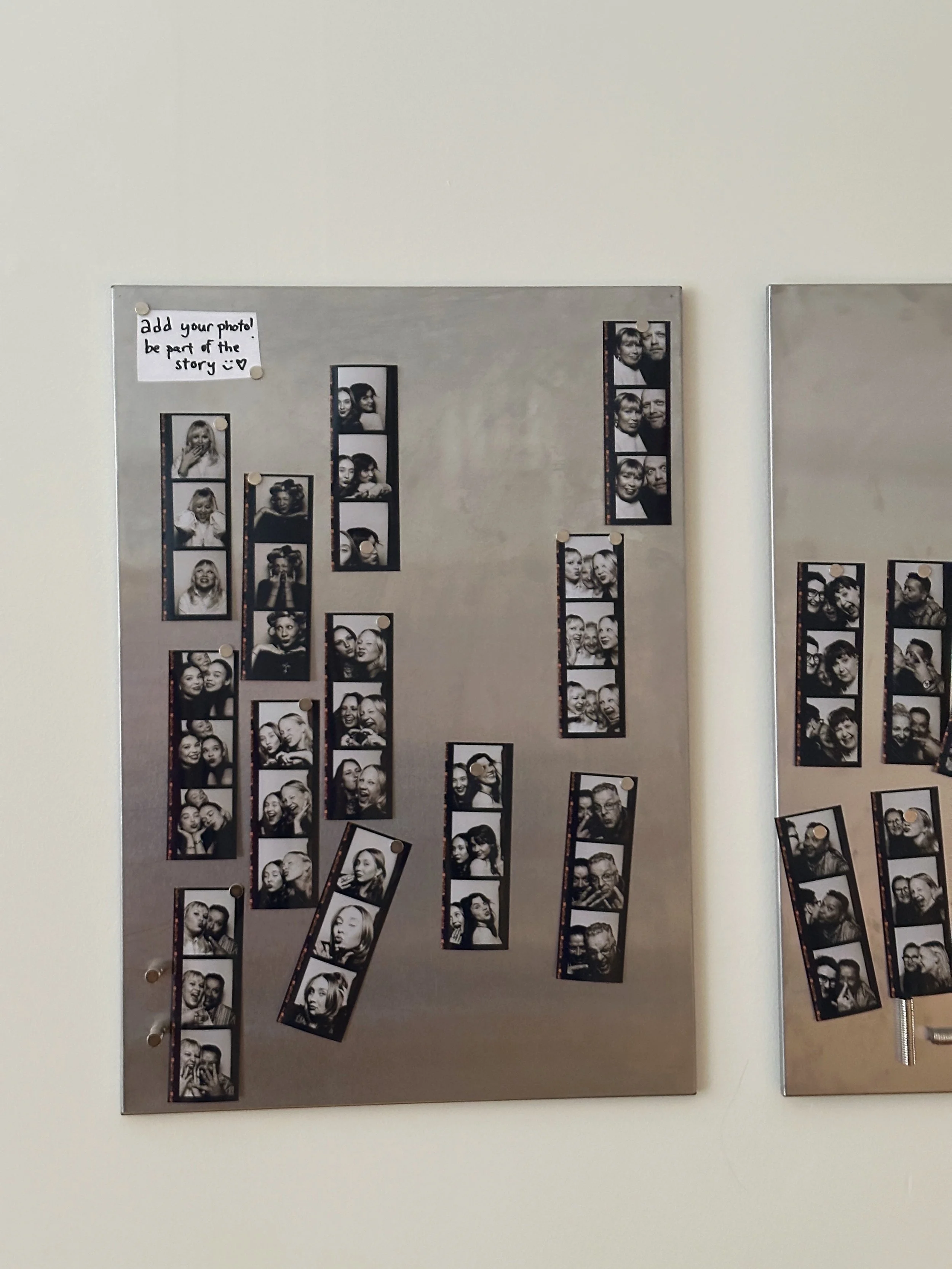 Valokuvamuistotaulu, jossa on monia mustavalkoisia valokuvia ihmishahmoista, osassa ihmisiä poseeraa ja on iloisia. Taulussa on myös muistiinpano, jossa lukee 'add your photo! be part of the story ♥'.