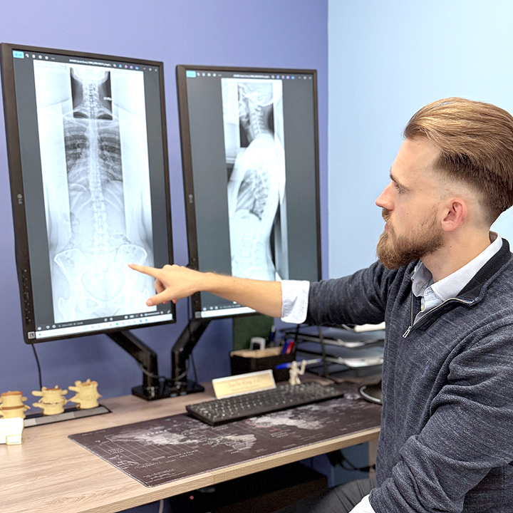 Chiropractor analysing x-ray images on the computer.