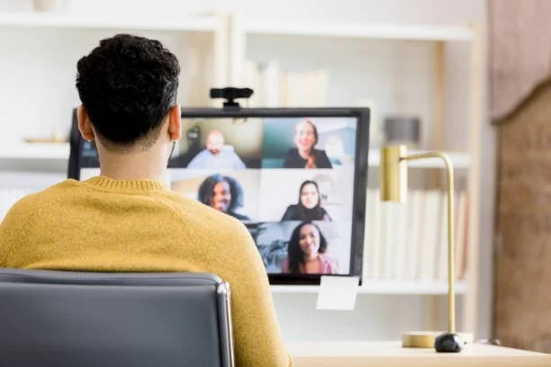 Person participating in a virtual meeting on a computer screen with multiple people. online seminar with presentation skills