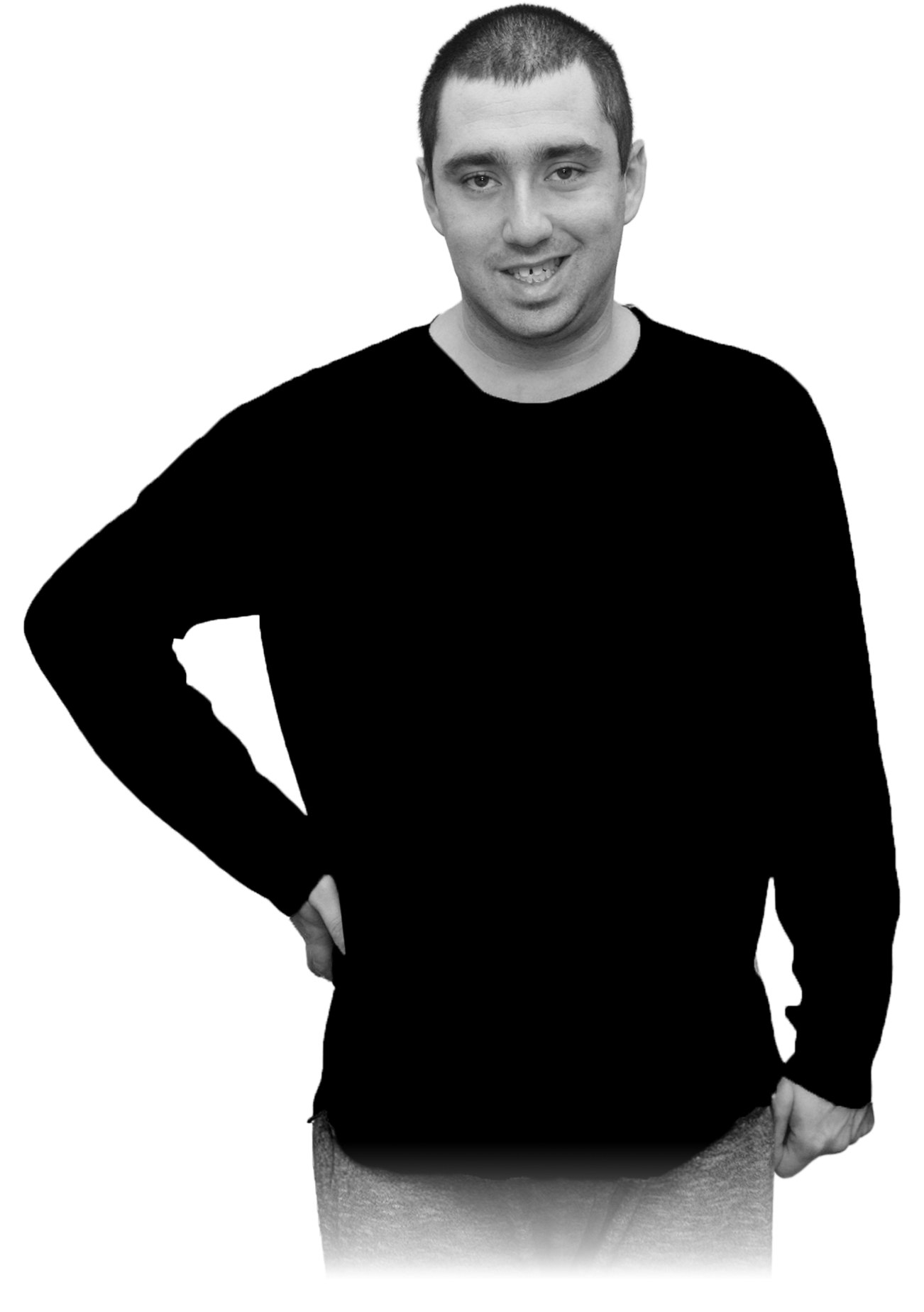 Young man with short hair, wearing a black long-sleeve shirt and pants, smiling with his right hand on his hip.