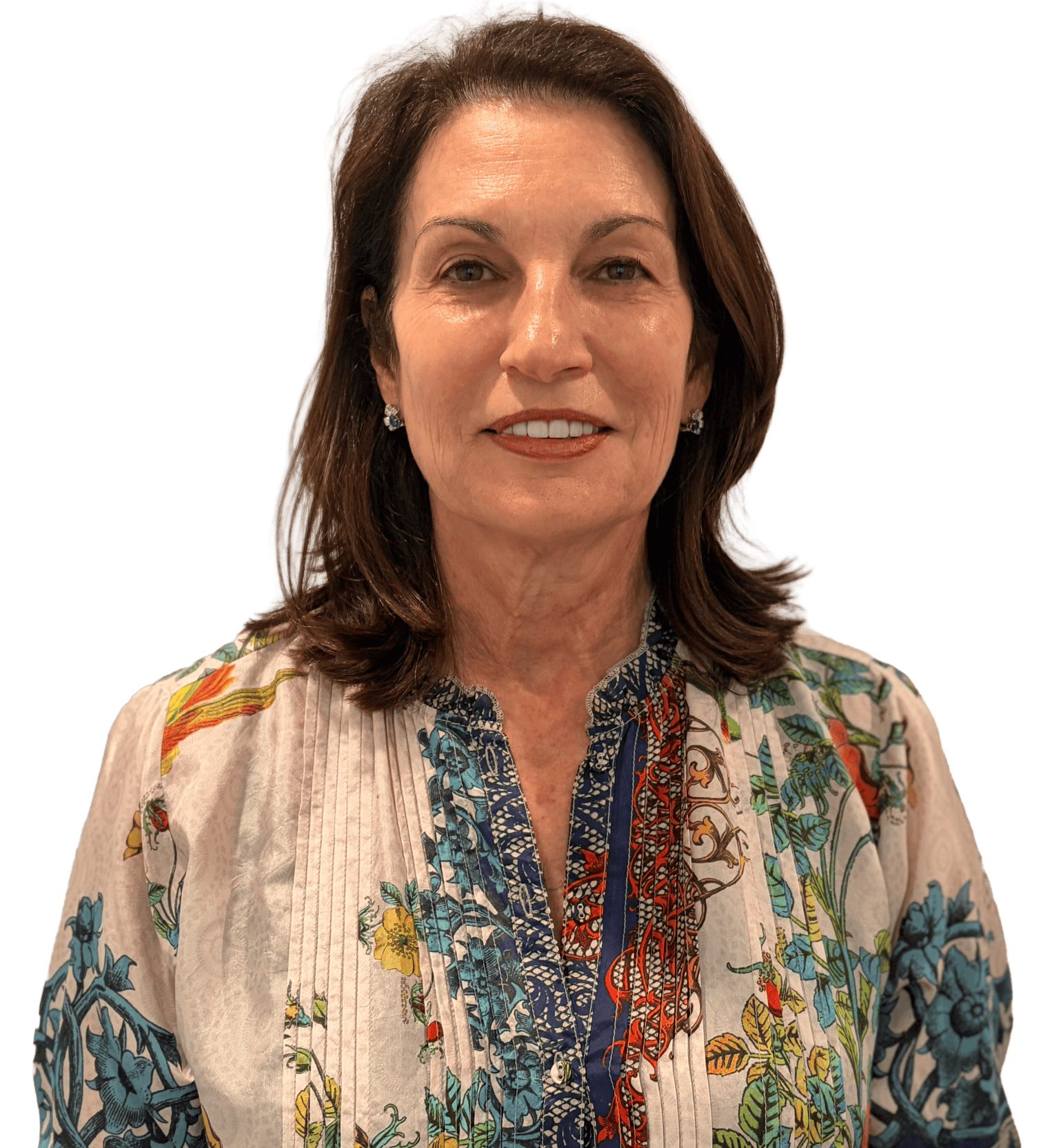 Profile of the chair of the board; a woman with shoulder-length brown hair, wearing earrings, and a multicolored floral-patterned blouse with a collar.