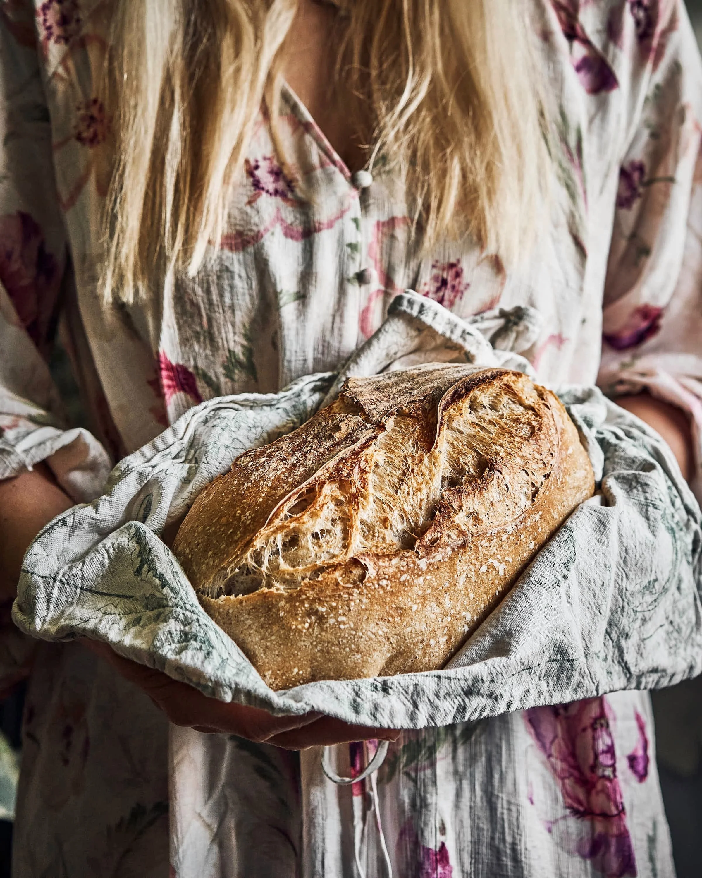 Roosas kleidis naine hoidmas köögirätikus hapusaiapätsi