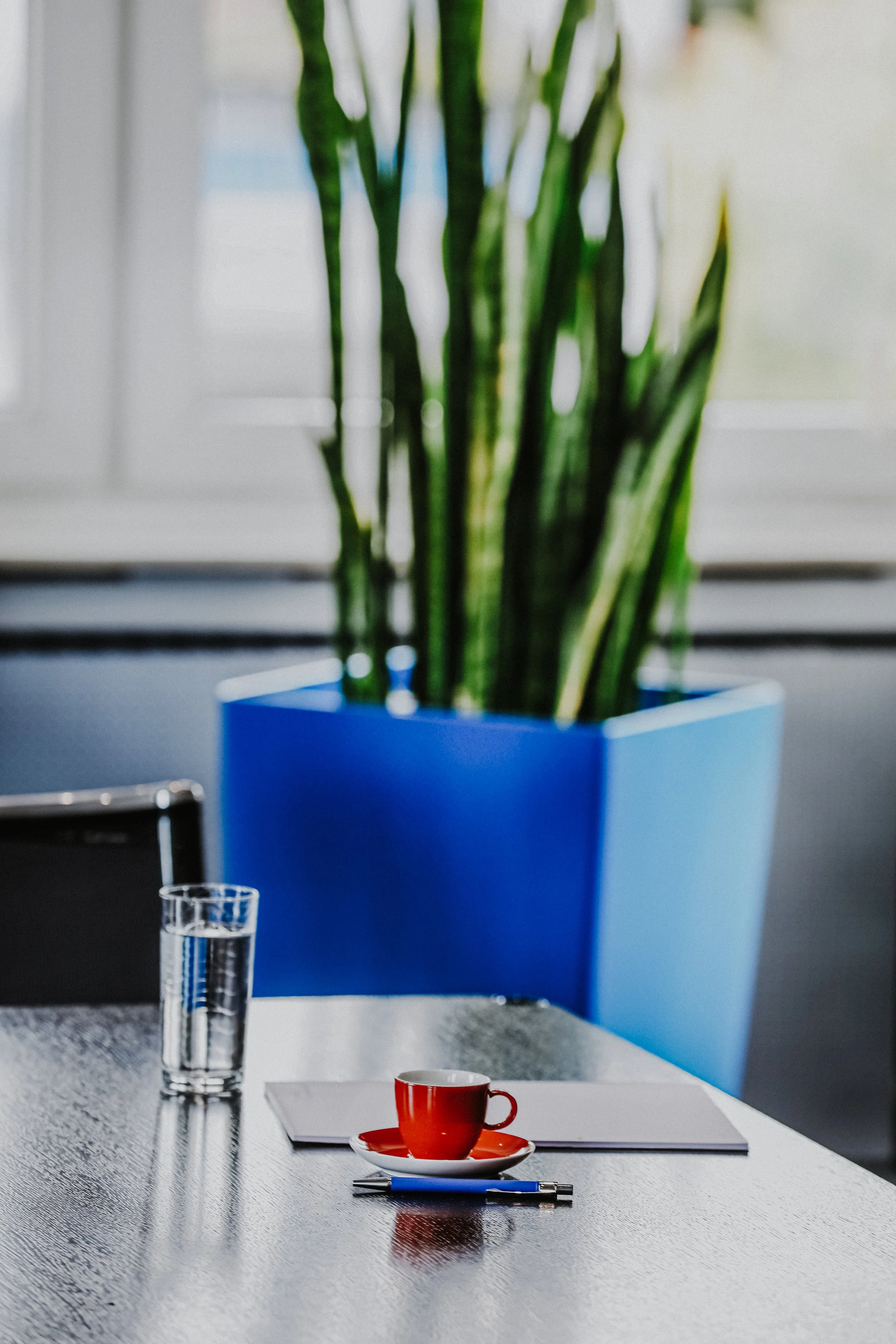 Ein Glas Wasser und eine Tasse Kaffee auf einem Konferenztisch