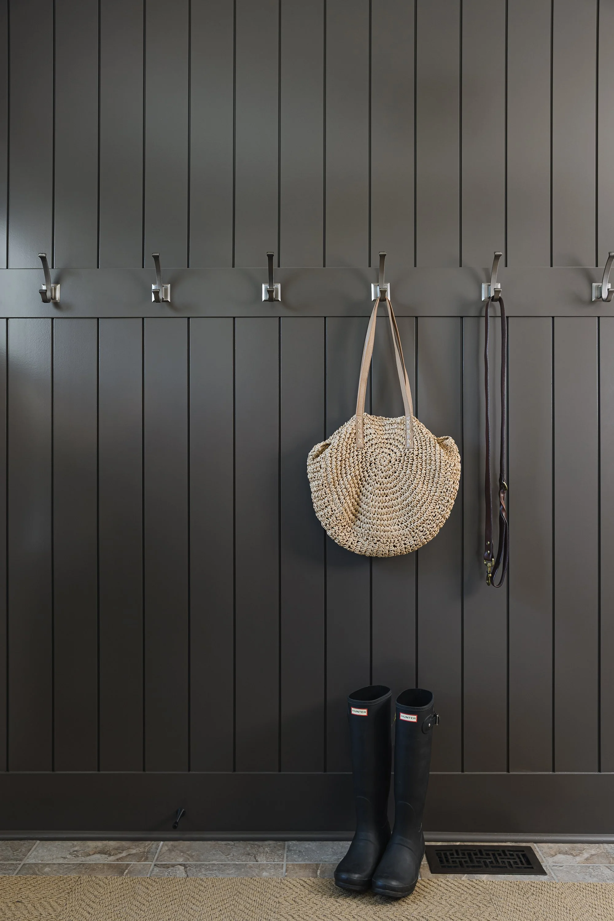 Mudroom design for an Ottawa family home featuring custom wall paneling and hooks. 
