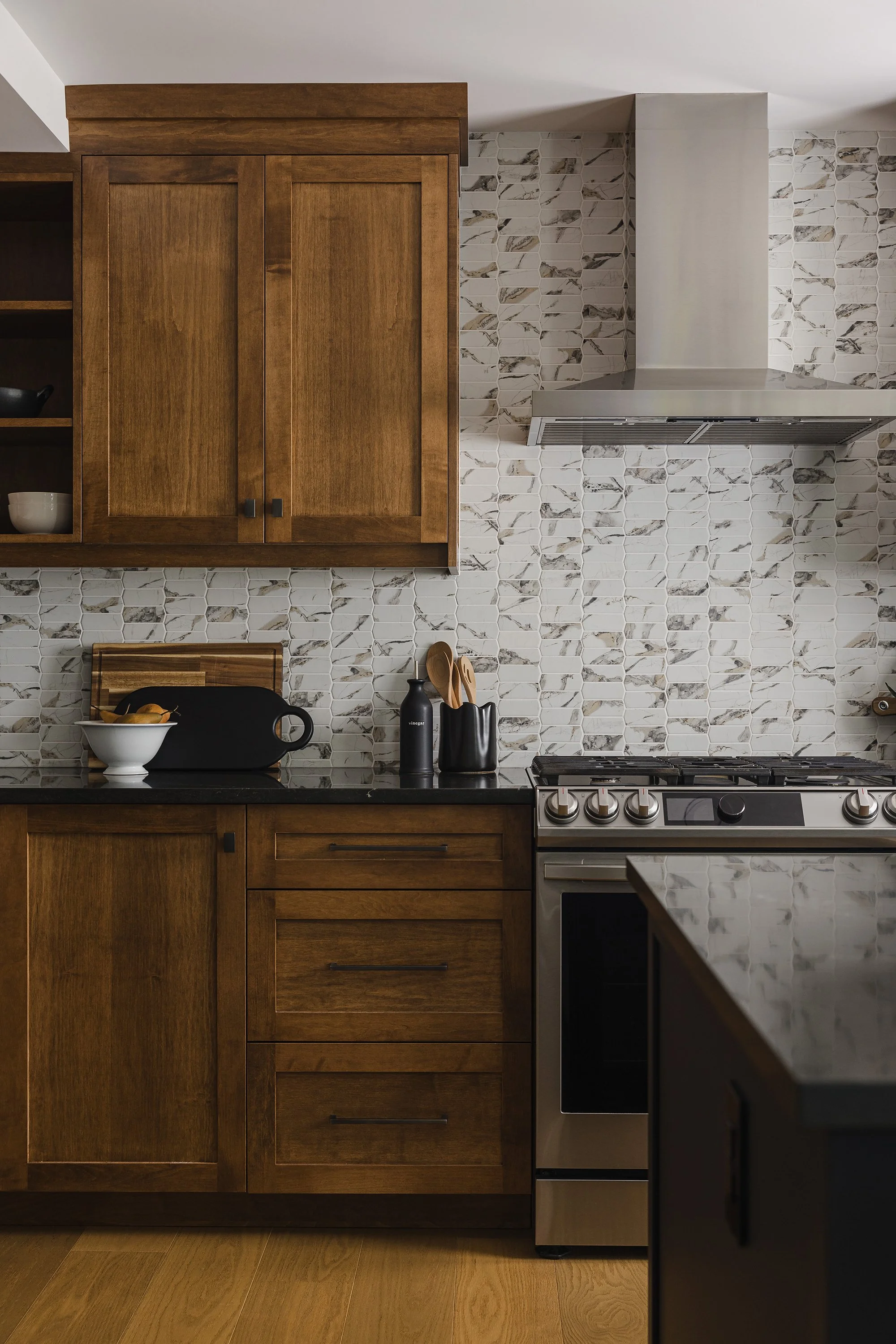 Custom kitchen renovation in Ottawa featuring warm maple cabinets and a recycled glass backplash. 