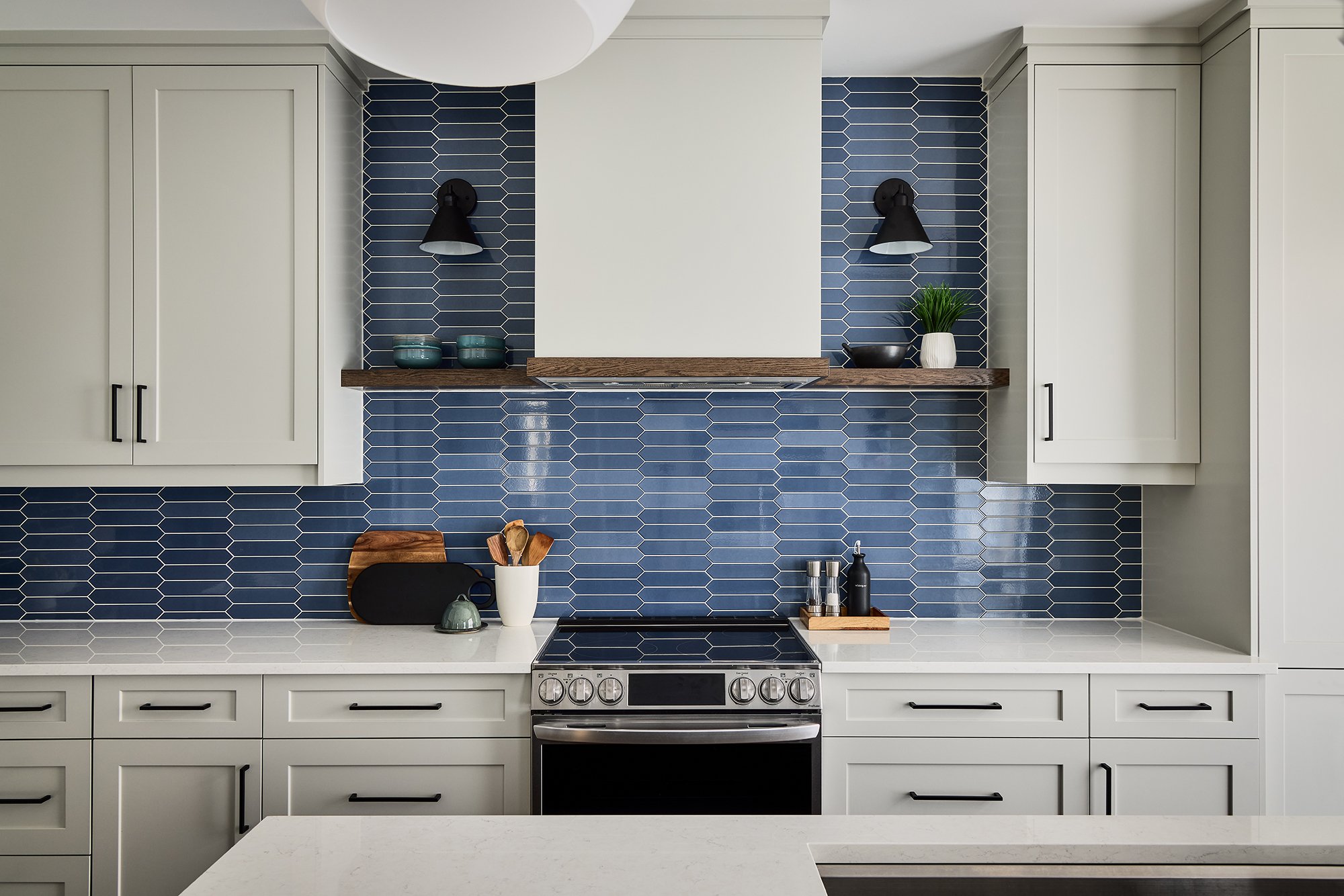 Custom kitchen renovation in Ottawa featuring light shaker cabinetry and blue picket backsplash.