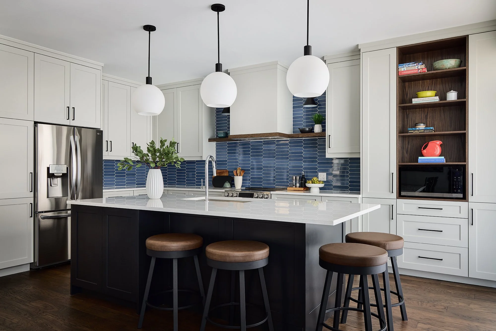 Custom kitchen renovation in Ottawa featuring light shaker cabinetry and a large black island with seating. 