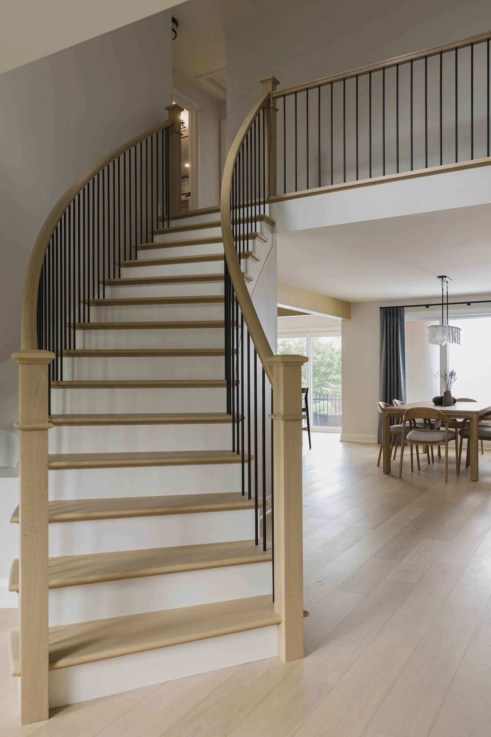 Renovation in Ottawa featuring a white oak staircase with black railings. 
