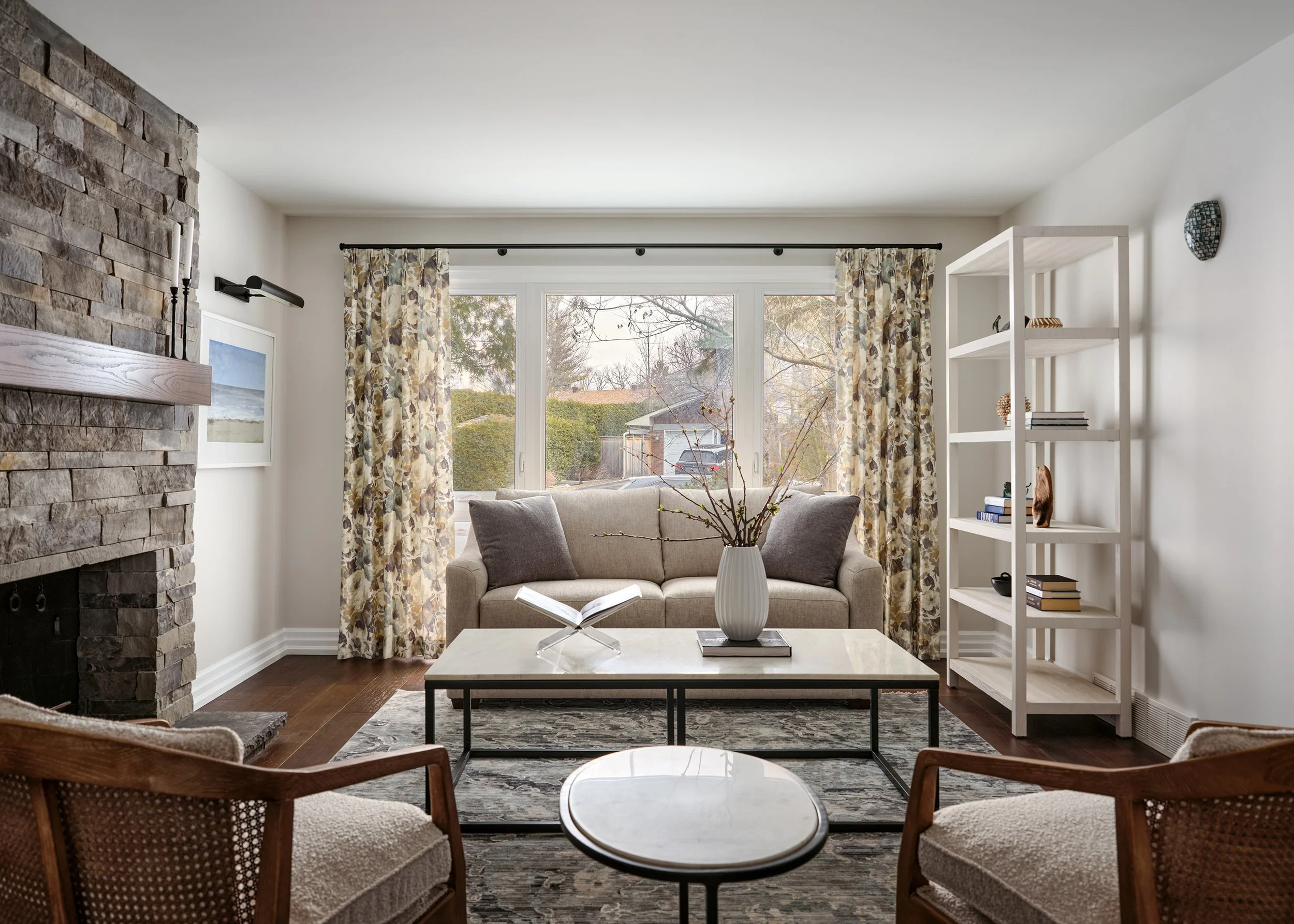 Living room design for an Ottawa family home featuring floral drapery and a stone fireplace.
