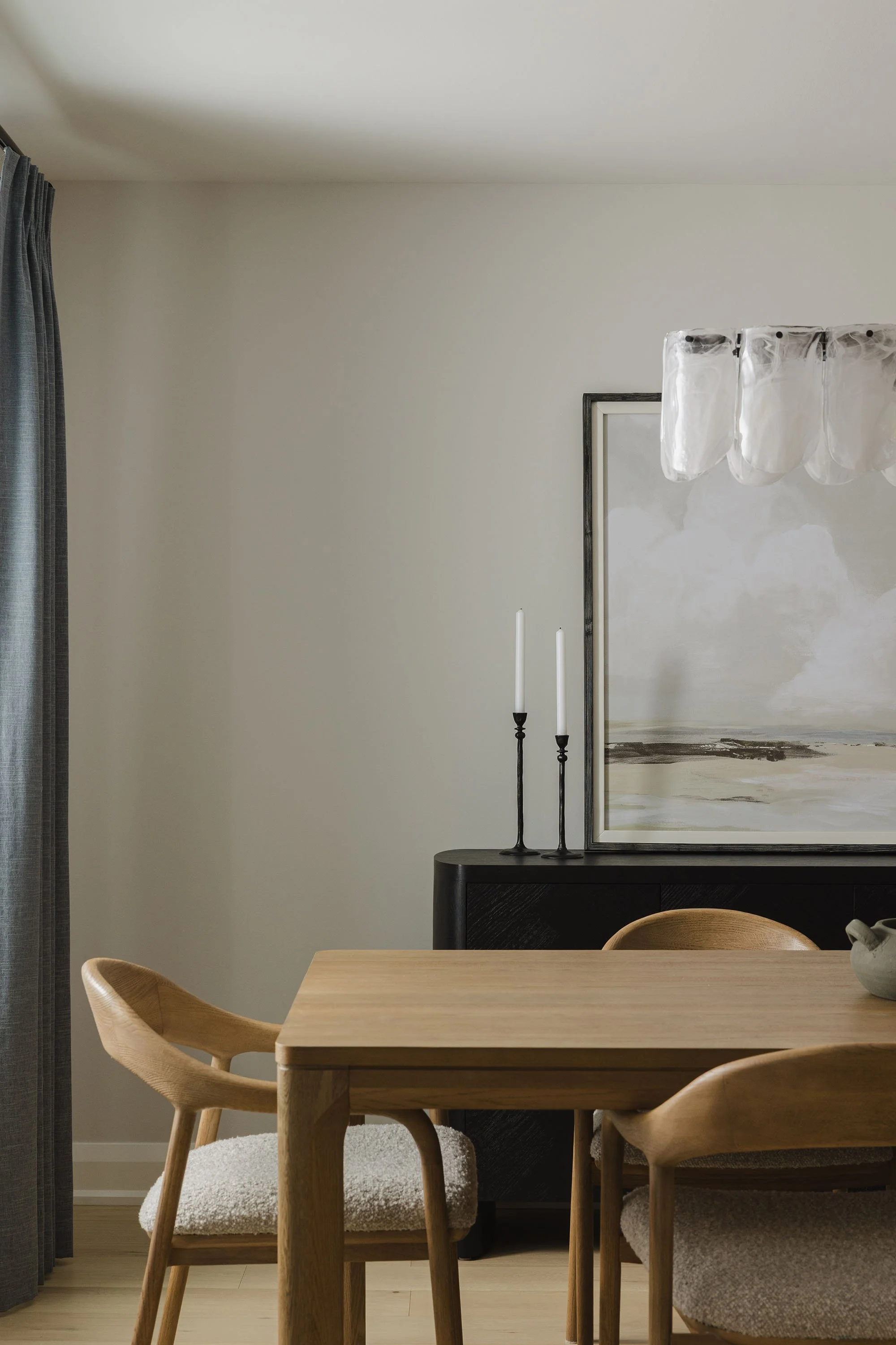 Kitchen renovation in Ottawa featuring a dining room with custom drapery and a white oak table and chairs and a black side board.