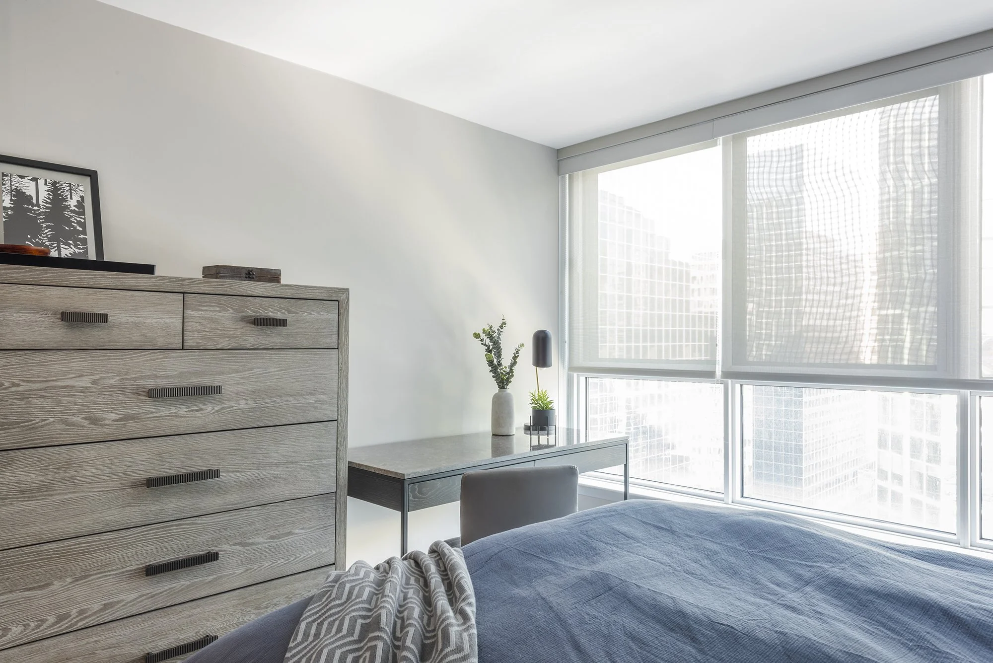 Ensuite bedroom makeover in Ottawa featuring a tall grey washed dresser and a large desk for working from home. 