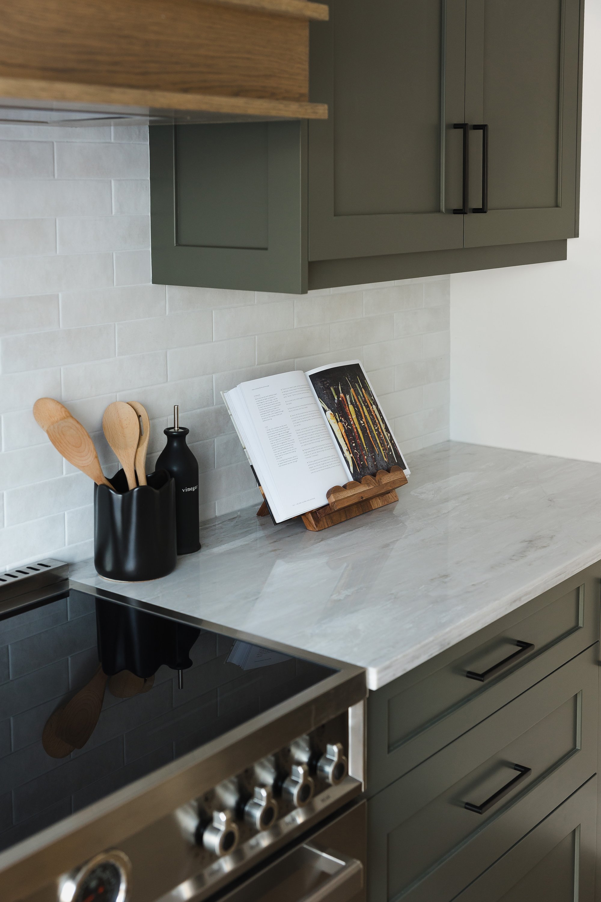 Custom kitchen renovation in Ottawa featuring green shaker cabinets and beautiful light coloured quartz counters. 