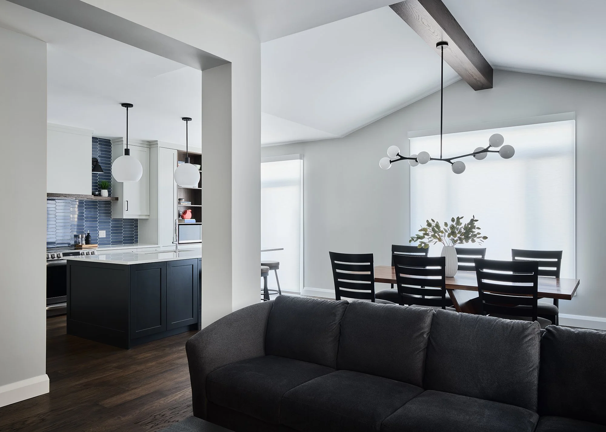 Main floor renovation in Ottawa featuring a custom kitchen with shaker cabinets and a large dining room with a wood beam. 