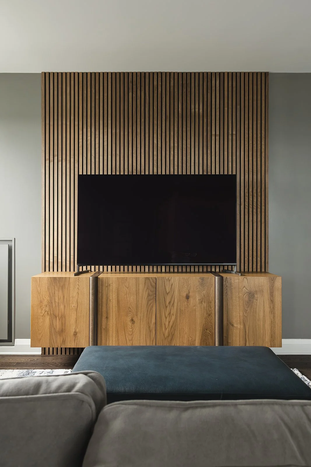 CPI Interiors luxury condo design with a slat wall behind a wood entertianment unit