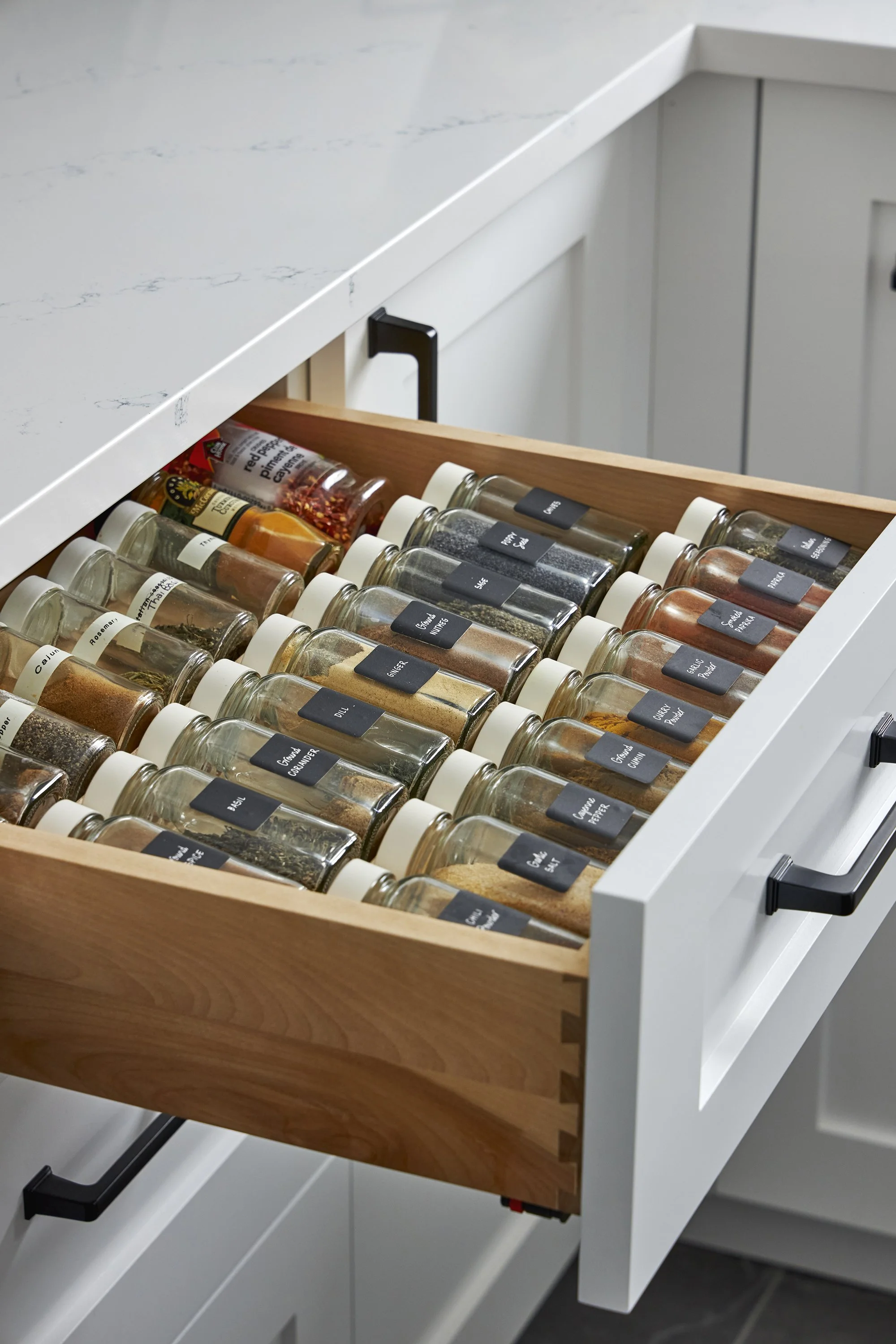 Custom kitchen renovation in Ottawa featuring white cabinets and a spice drawer.