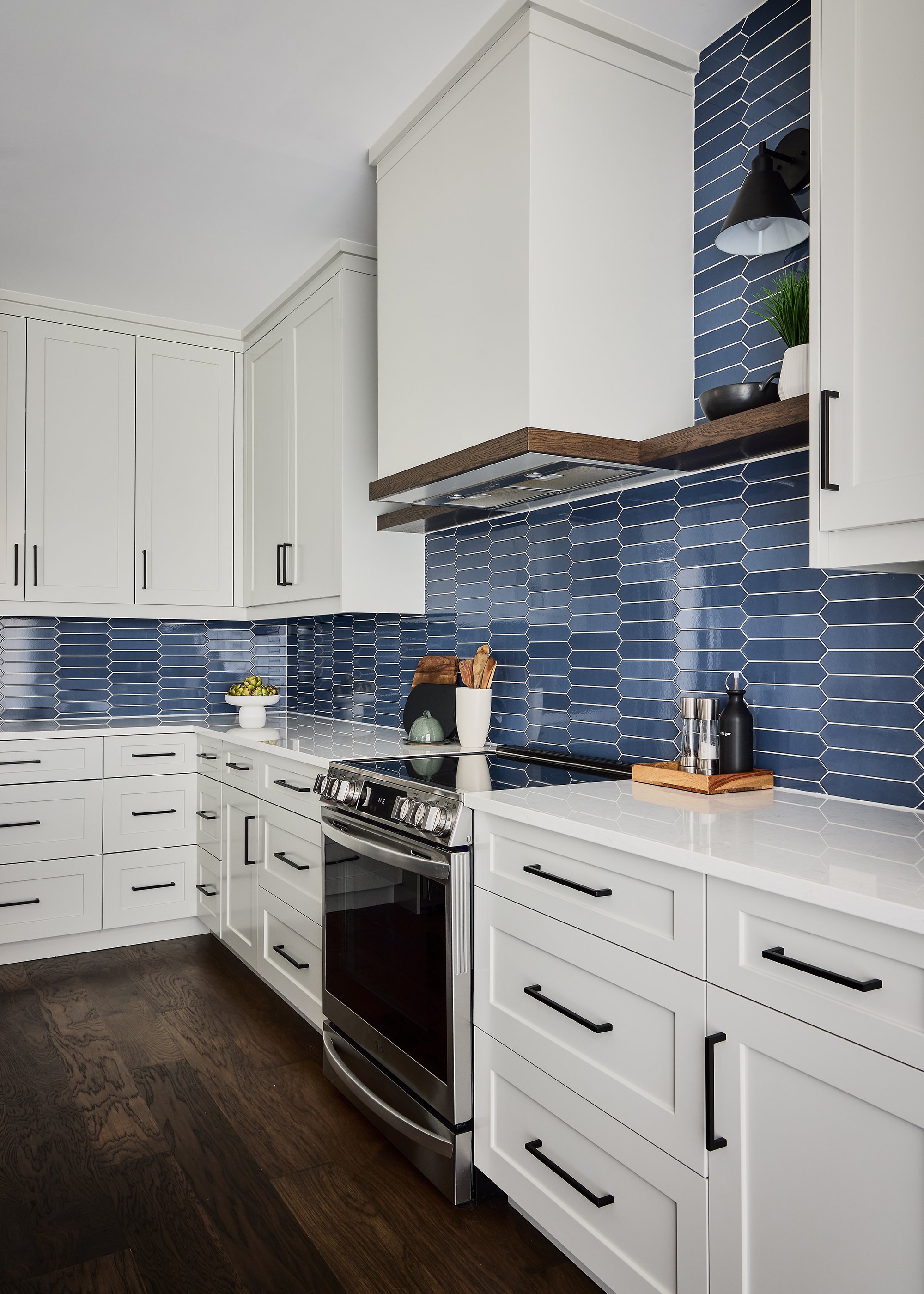 Custom kitchen renovation in Ottawa featuring light shaker cabinetry and a decorative hood fan. 