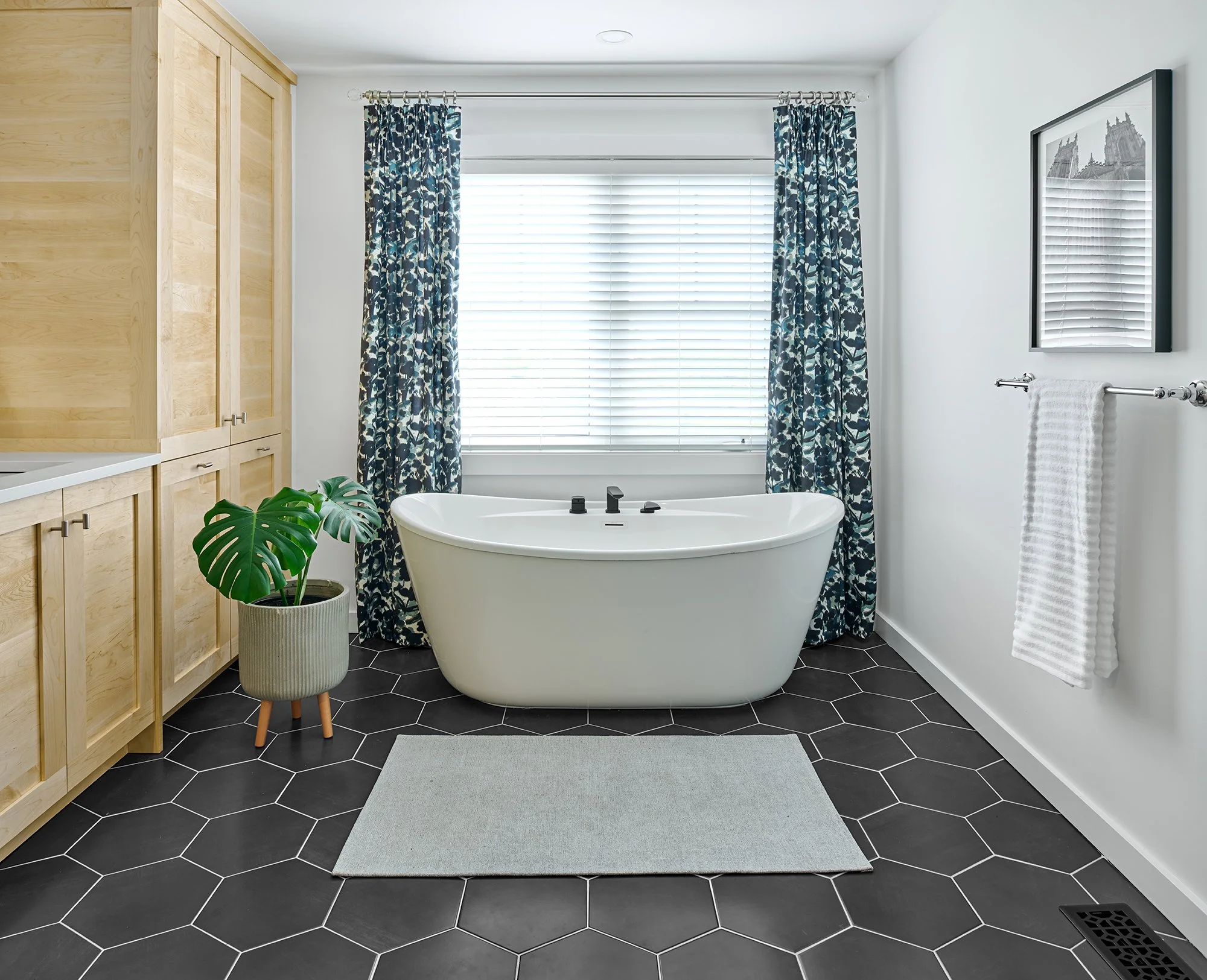 Custom ensuite renovation in Ottawa featuring a natural maple vanity and freestanding tub with custom drapery.