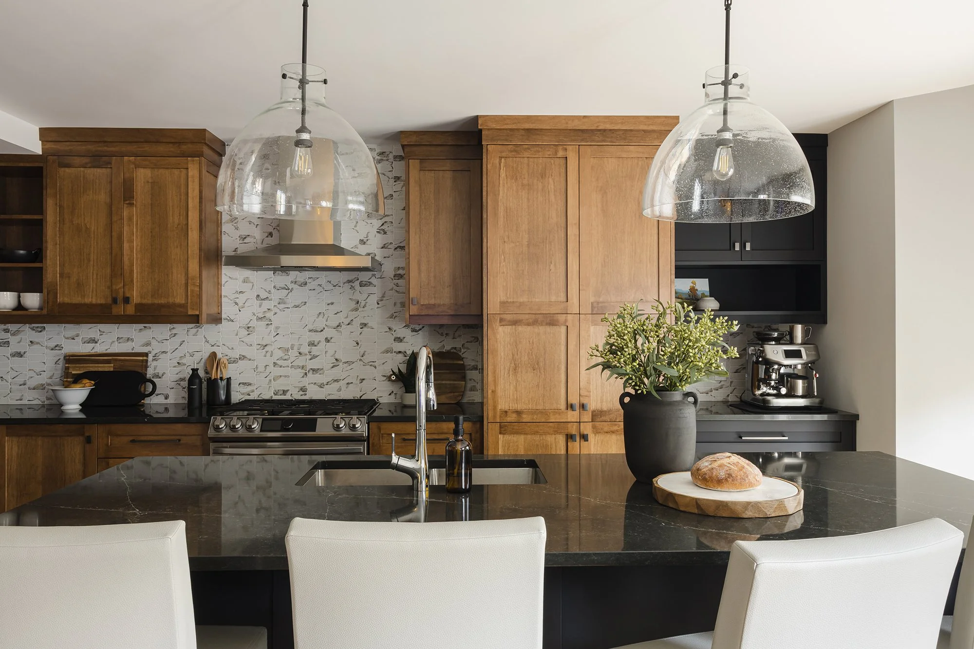 Custom kitchen renovation in Ottawa featuring warm maple cabinets and oversized pendants.