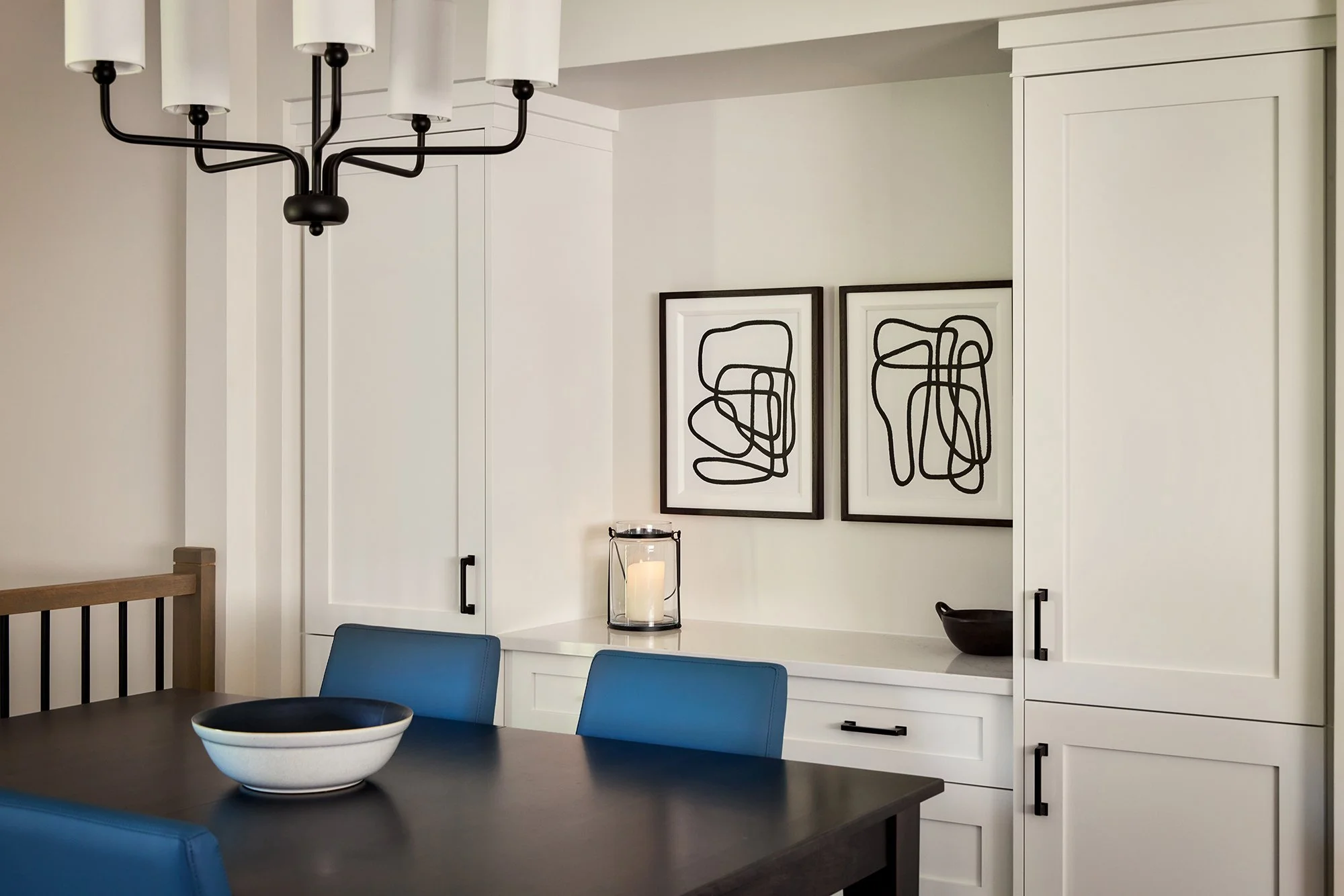 Open concept home design for an Ottawa family home featuring custom cabinetry in the dining room and abstract art. 