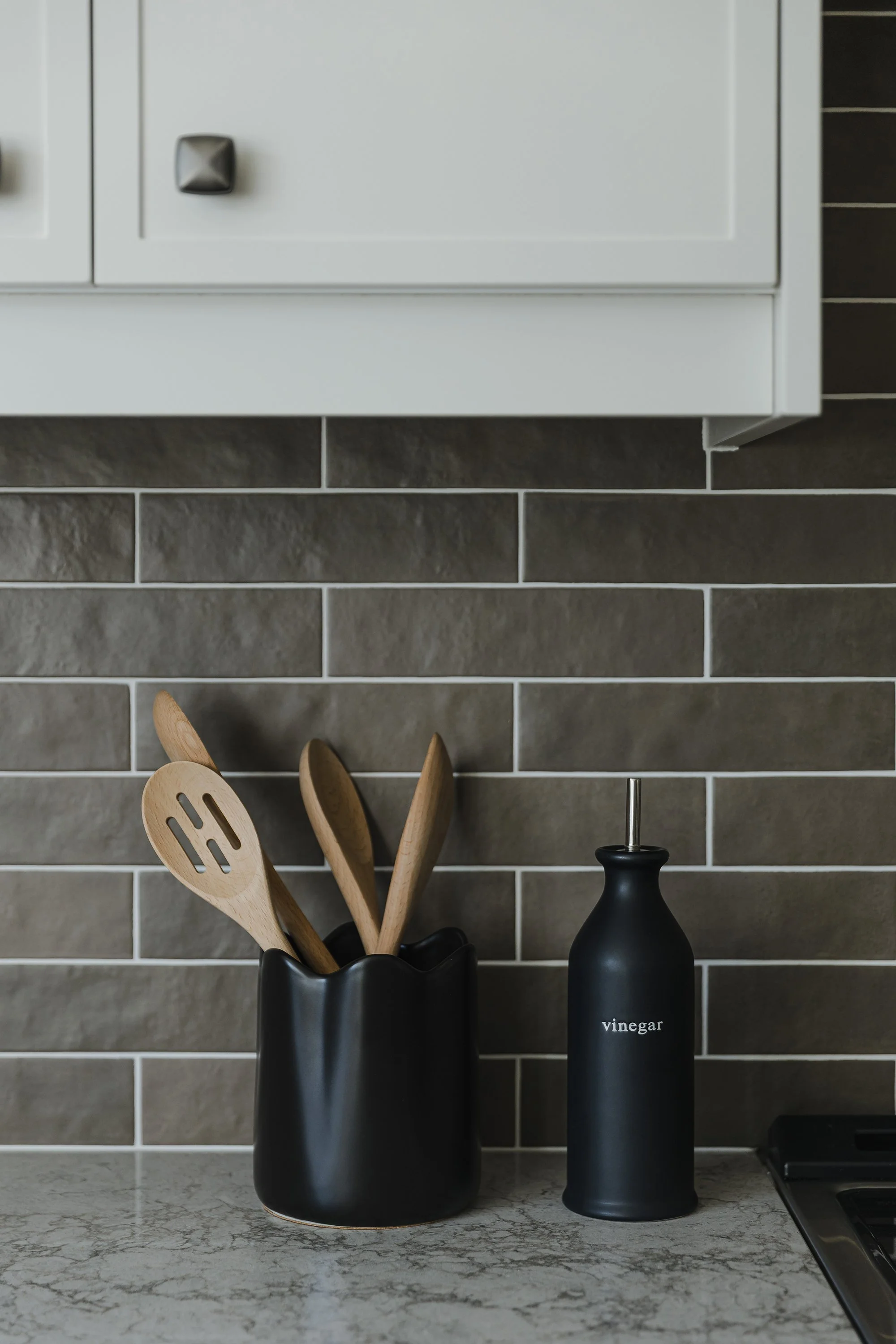 Custom kitchen design for an Ottawa family home featuring a dark brown textured backplash.