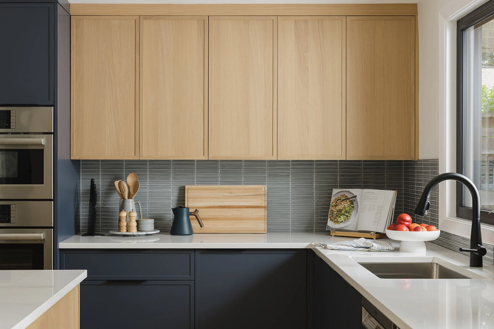 Ottawa interior design featuring a mid-century modern kitchen with white oak cabinetry and painted dark blue cabinetry.