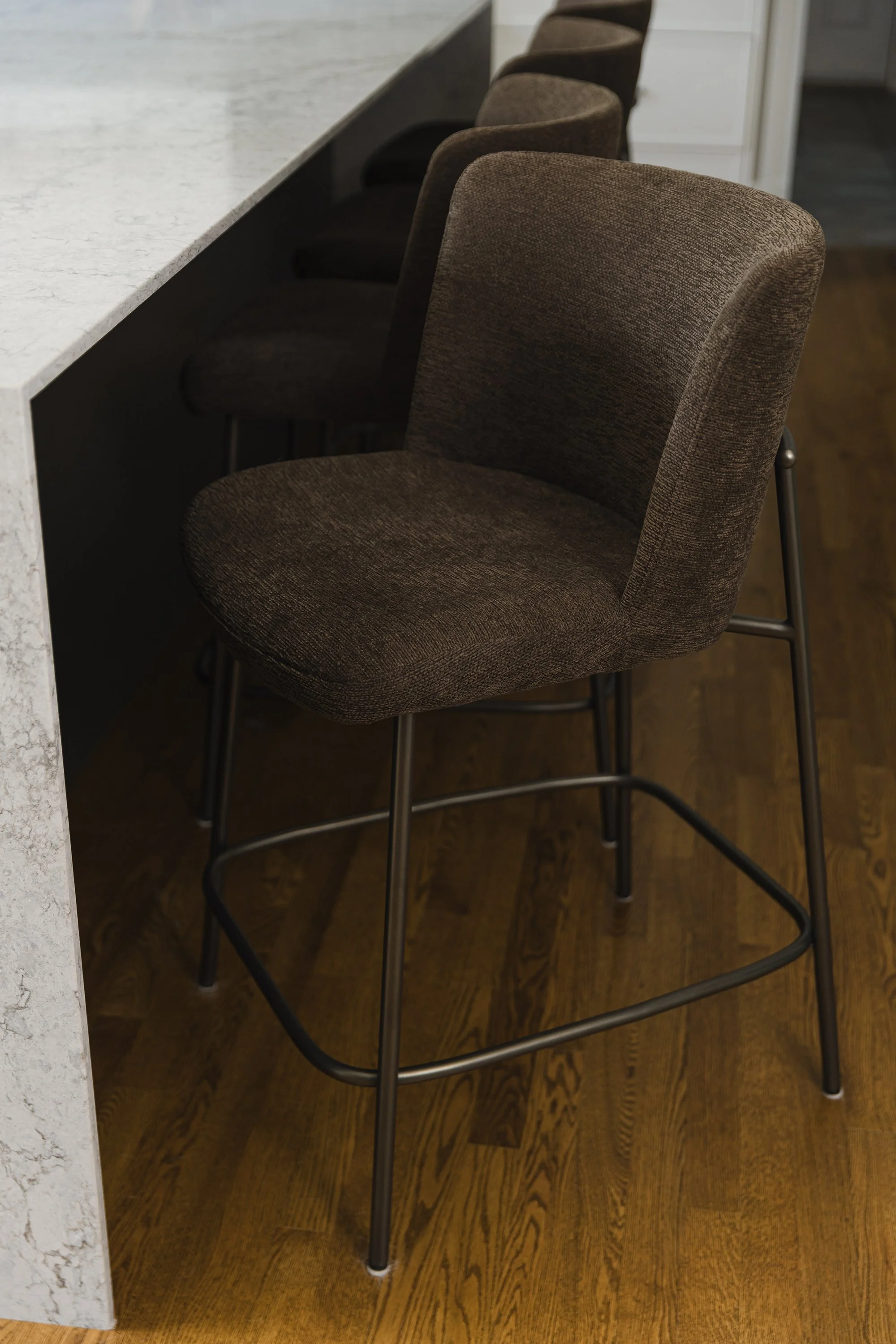Custom kitchen design for an Ottawa family home featuring rich brown counter stools.