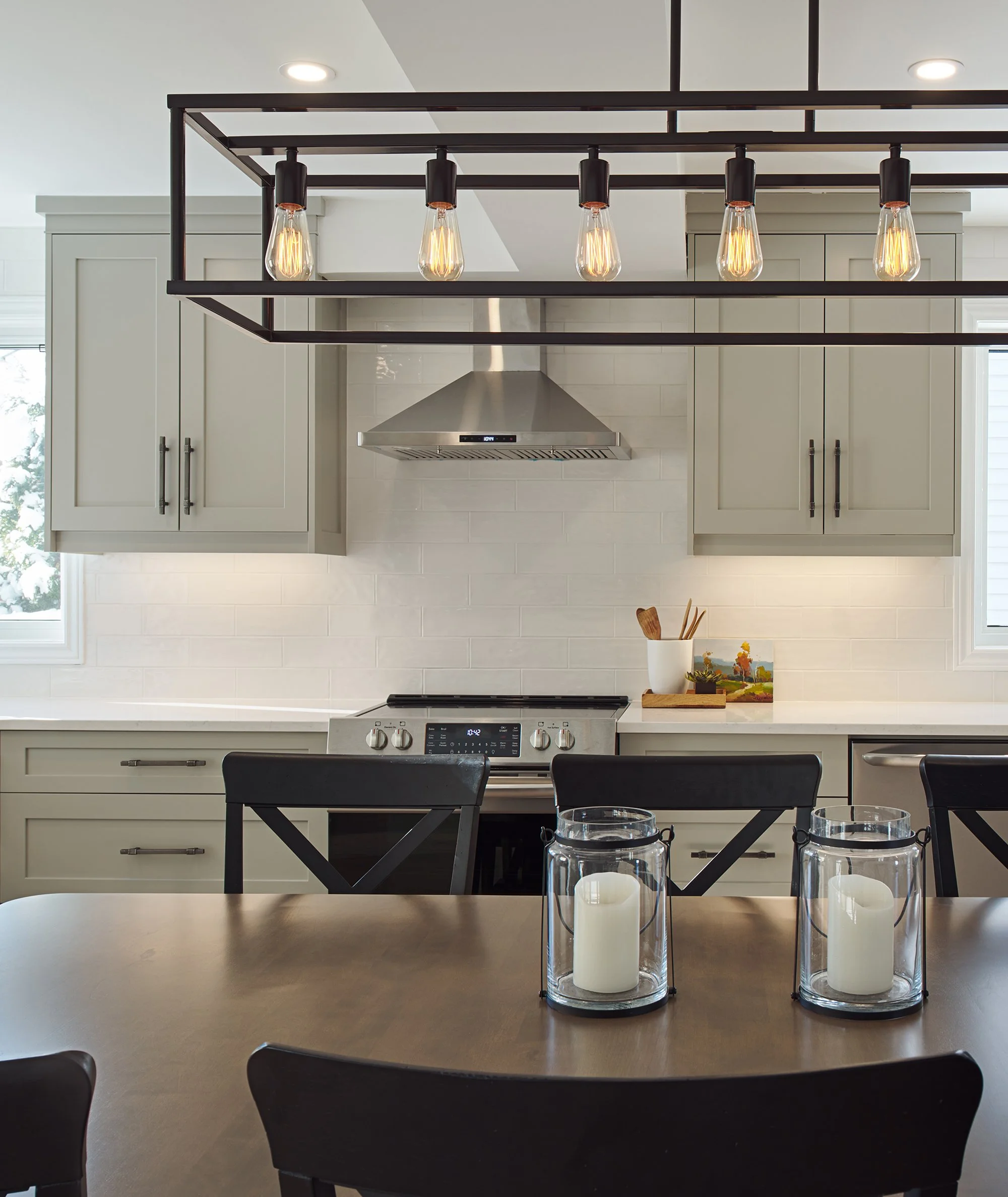 Custom kitchen renovation in Ottawa featuring warm grey shaker cabinets and an industrial chandelier. 