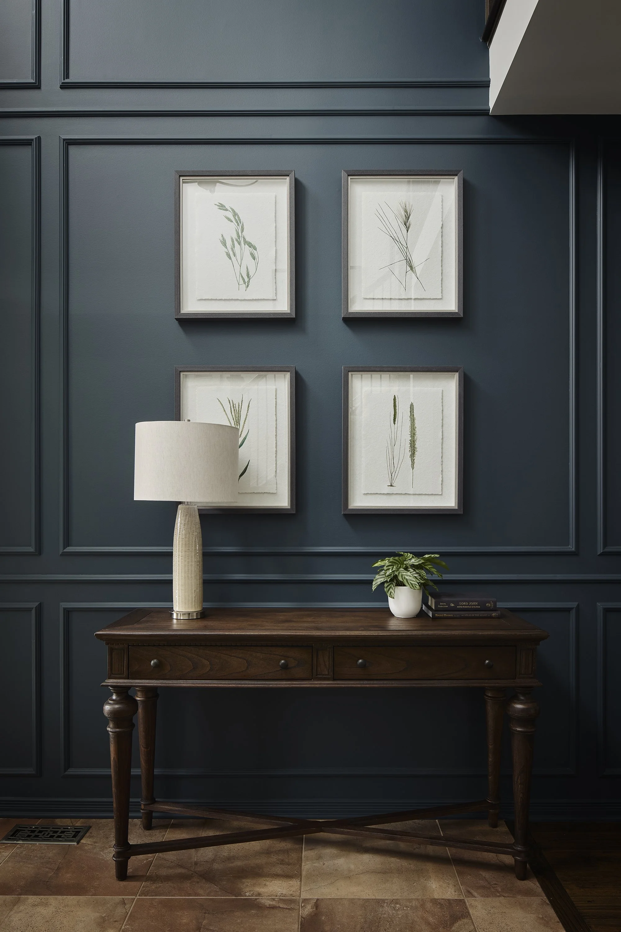 Foyer renovation in Ottawa featuring decorative moulding in a deep rich teal and a gorgeous console and botanicals. 