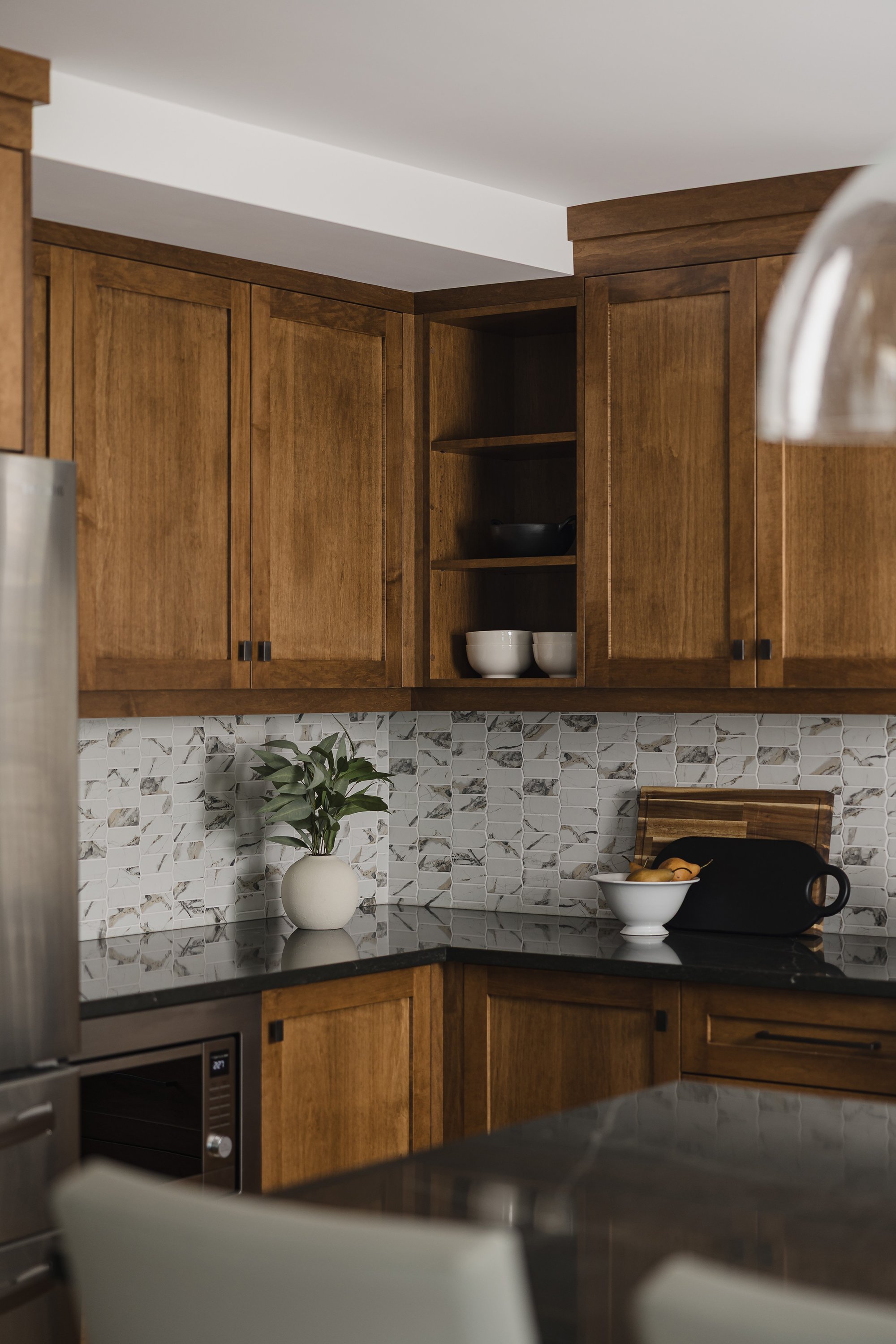 Custom kitchen renovation in Ottawa featuring warm maple cabinets and open shelves for cookbooks. 