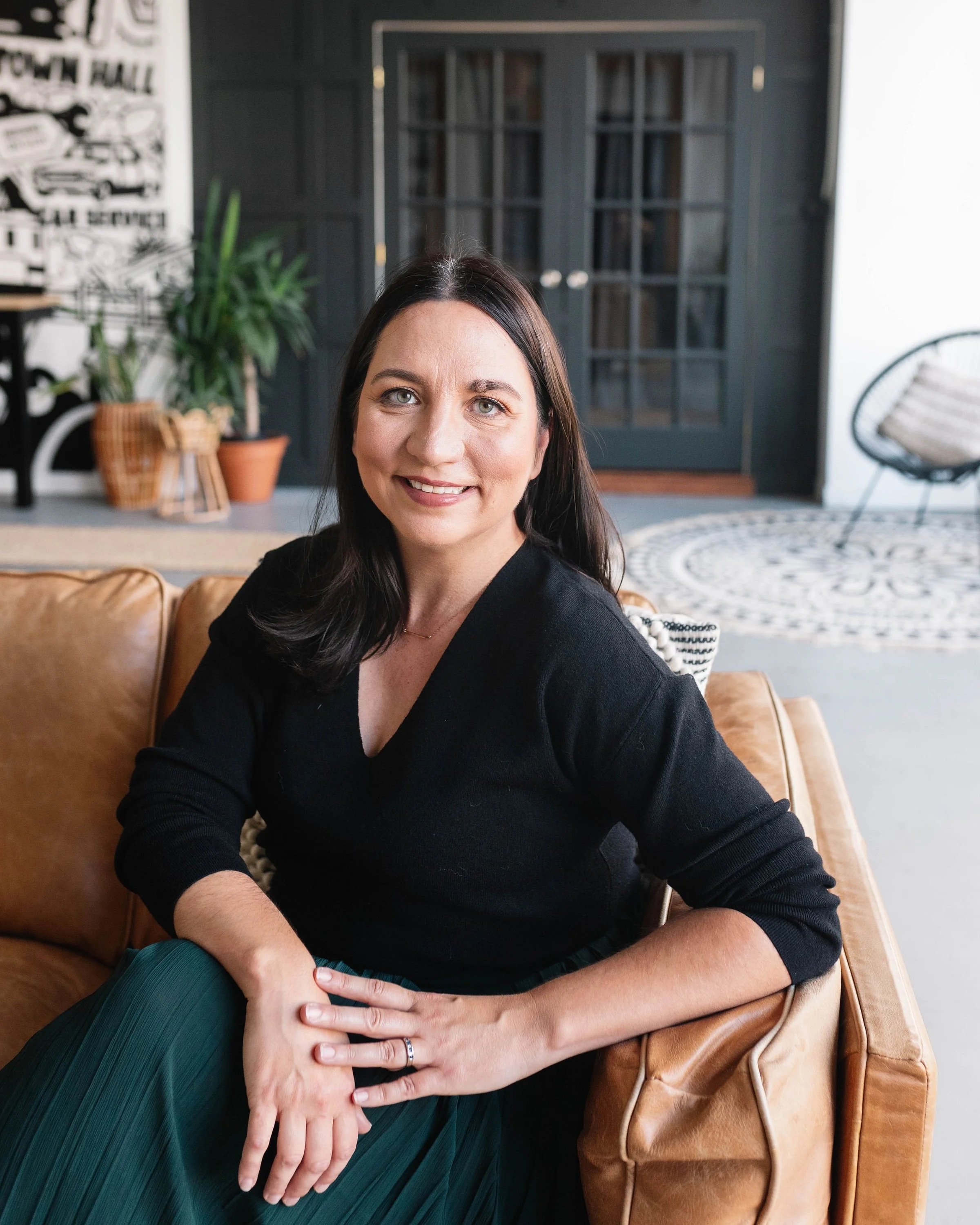 Natalie Cox, principal designer of CPI Interiors, an Ottawa interior design firm is sitting on a sofa..