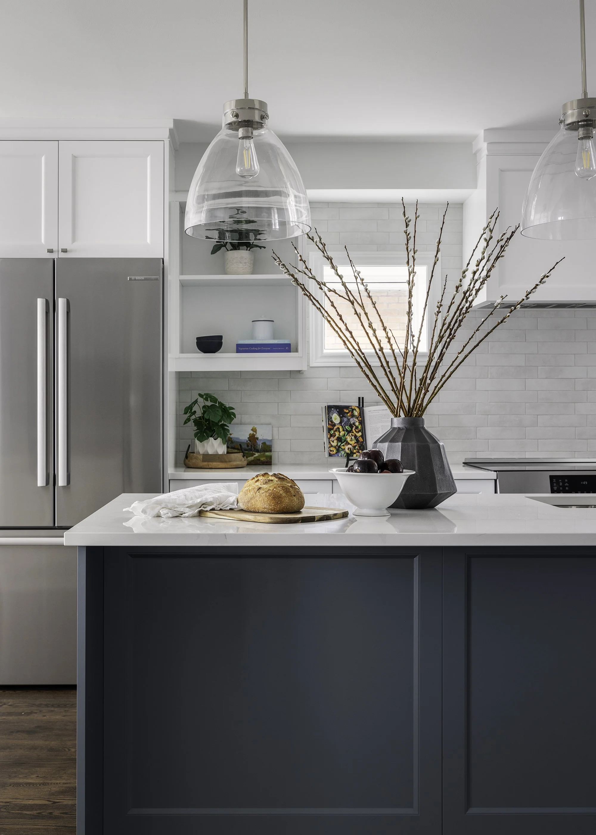 Custom kitchen renovation in Ottawa featuring white shaker cabinetry and a blue island.