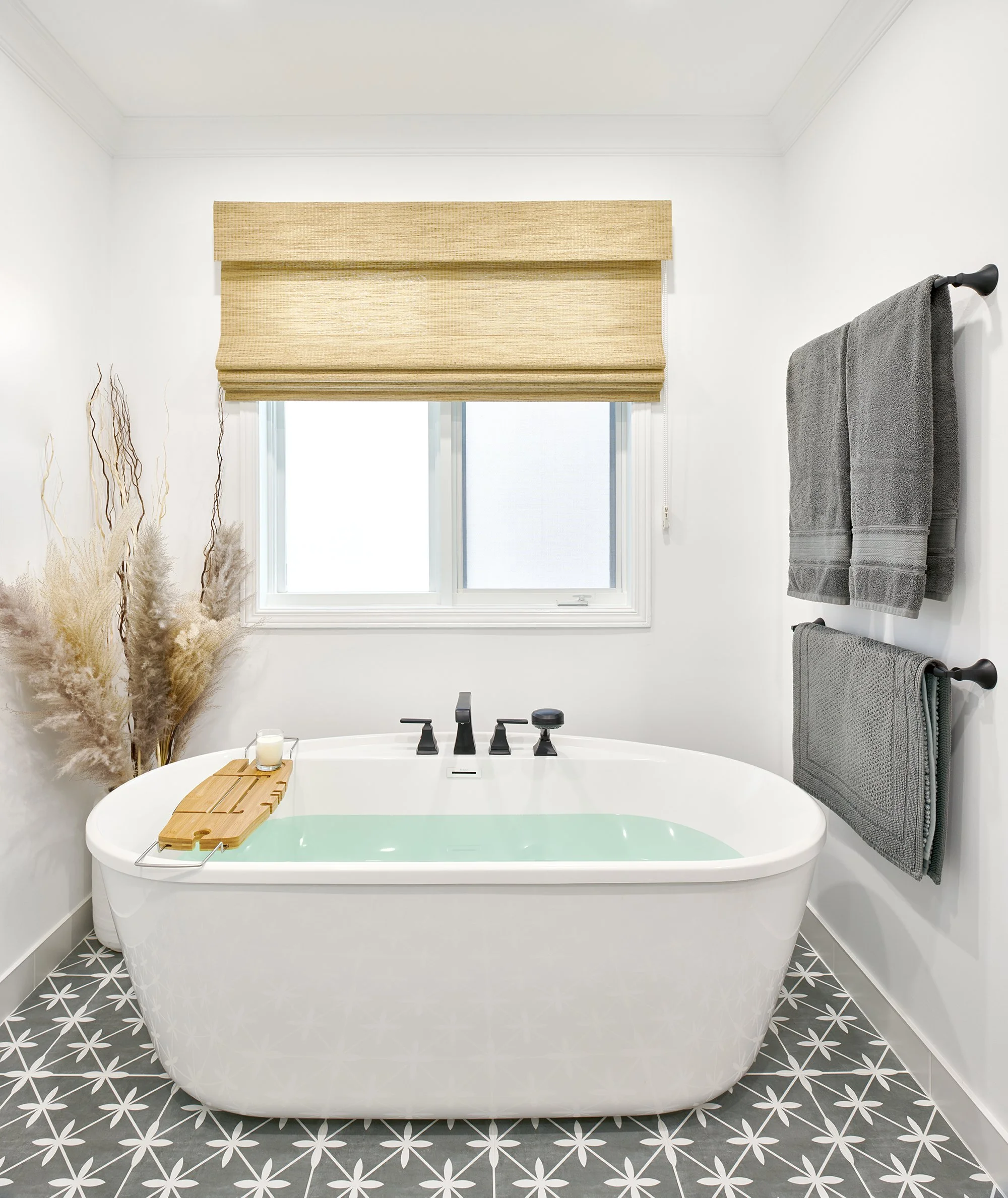 Ensuite bathroom design for an Ottawa family home featuring a freestanding tub sitting on patterned floor tile. 