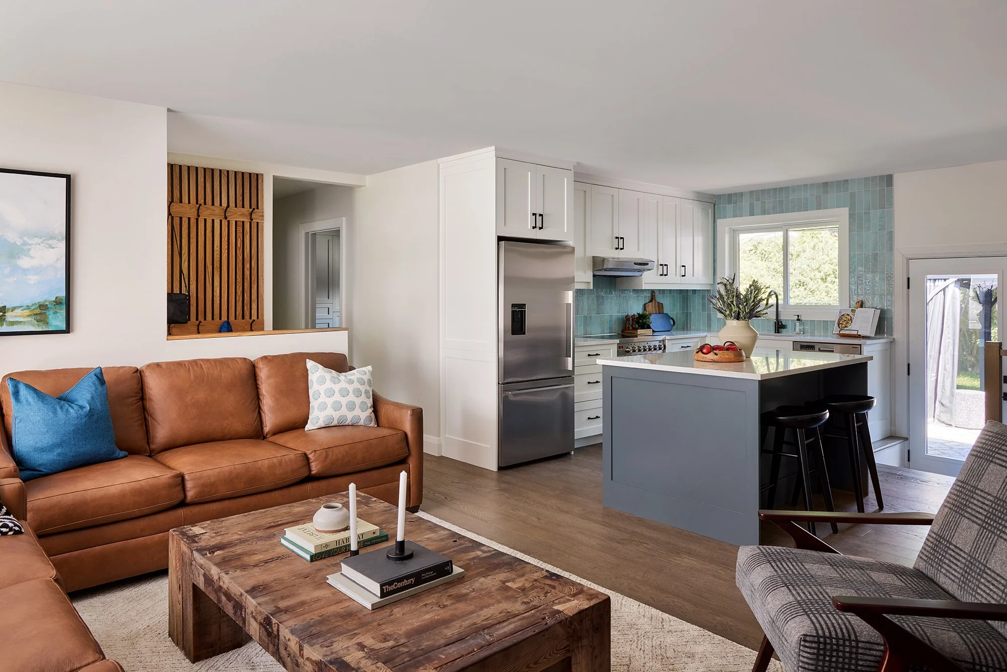 Open concept home design for an Ottawa family home featuring cognac leather sofas and seating at the island.