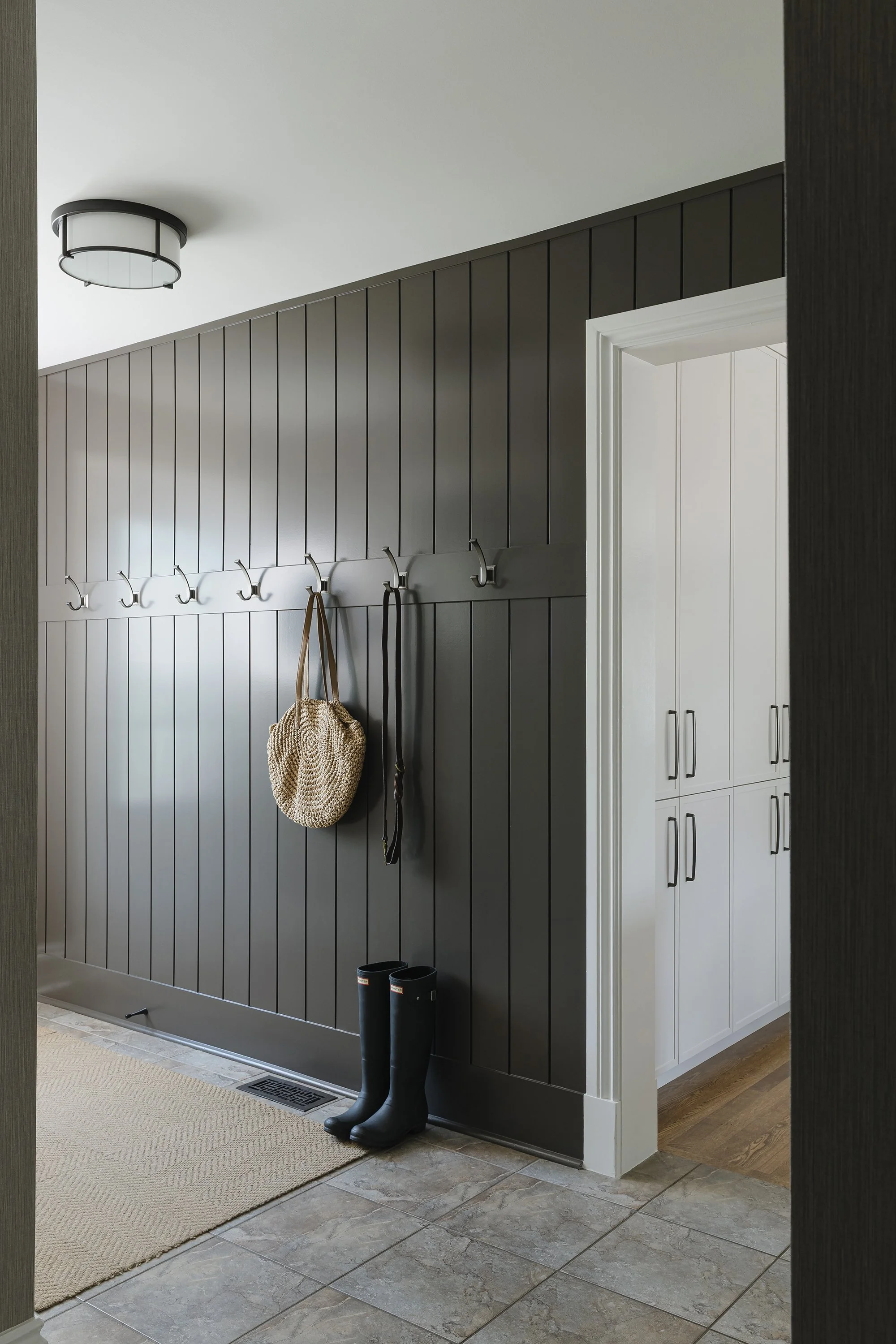 Mudroom design for an Ottawa family home featuring custom wall paneling.