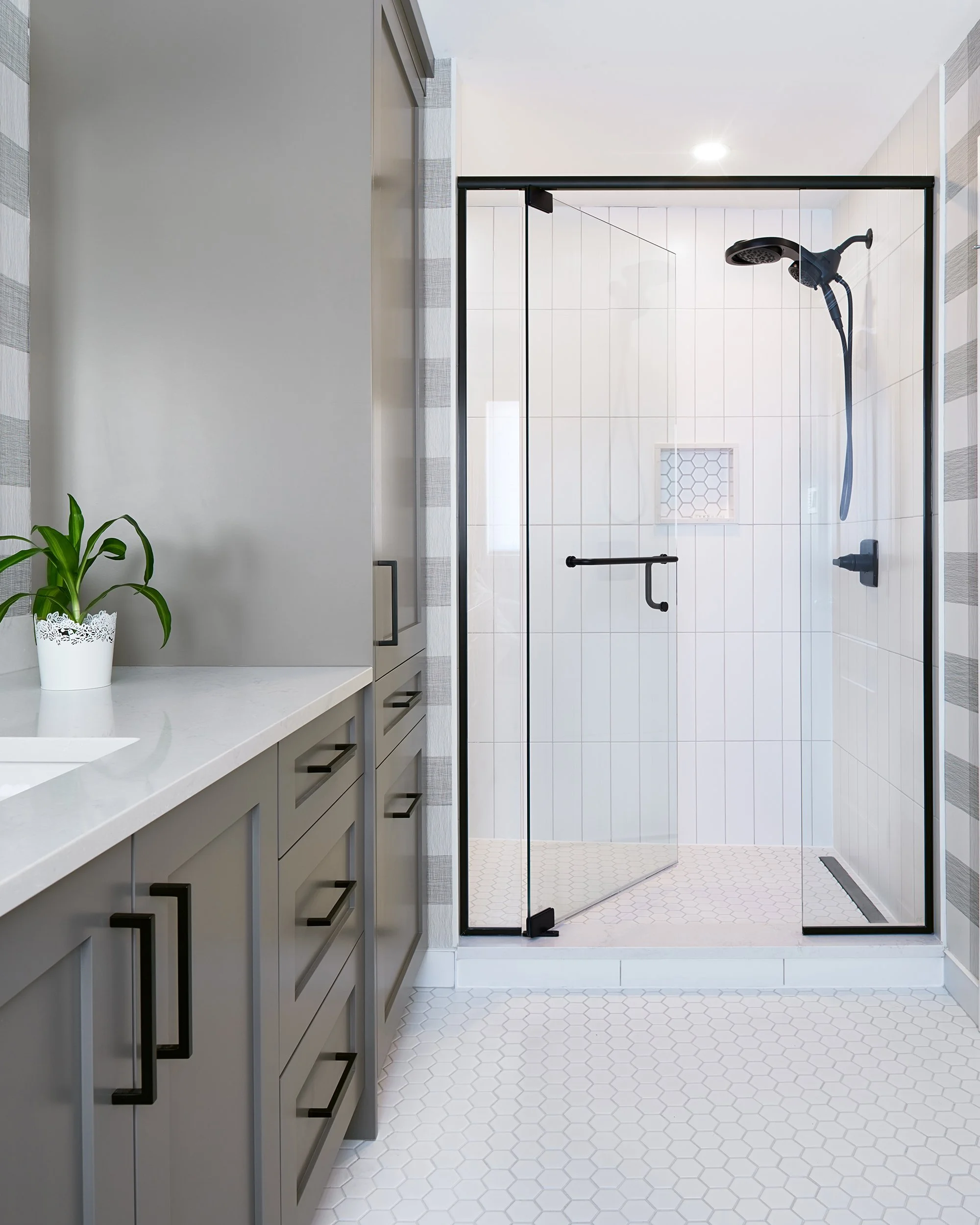 Ensuite bathroom renovation in Ottawa featuring custom grey vanity with a storage tower. 