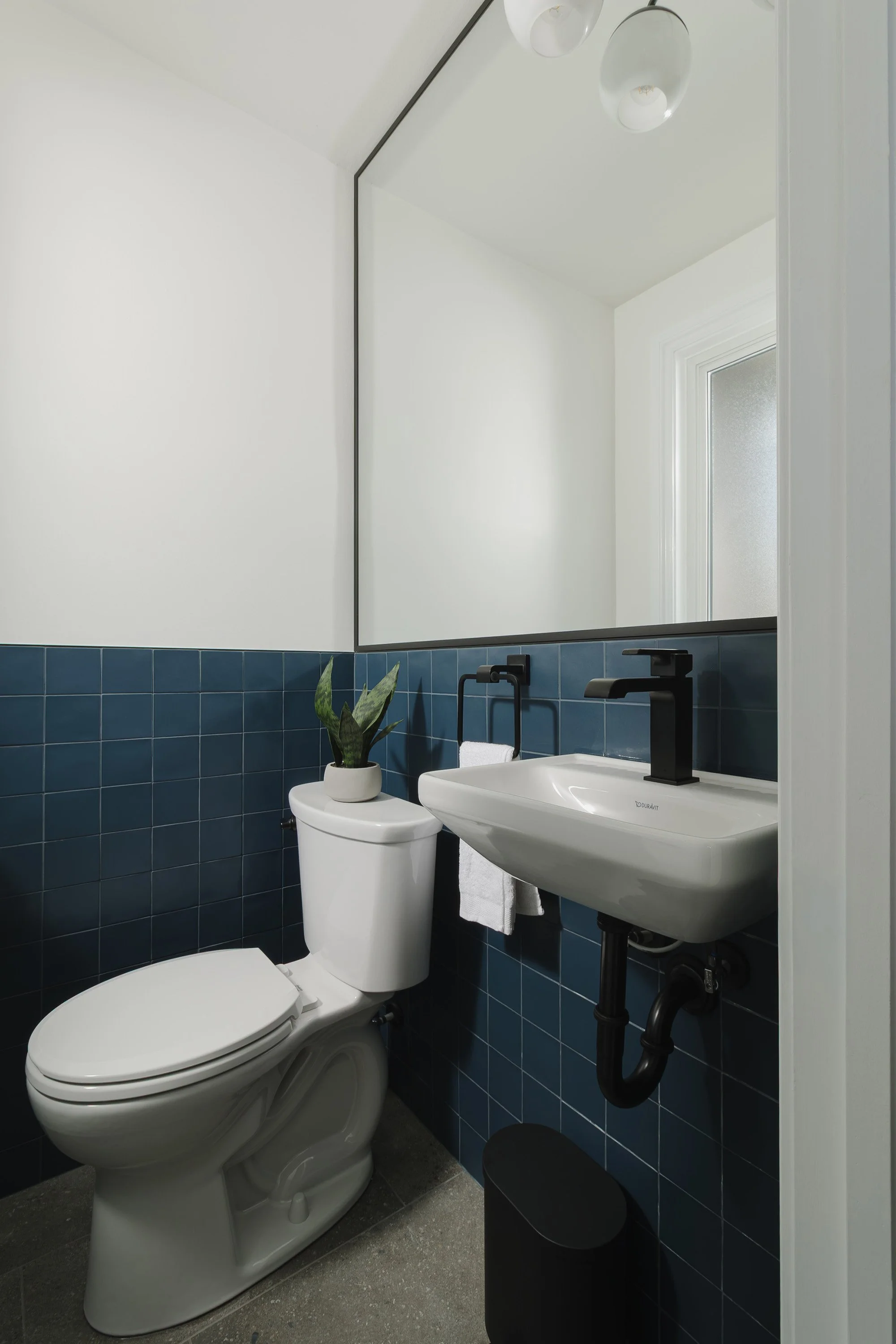 Ottawa interior design featuring a mid-century inspired powder room with blue wall tile. 