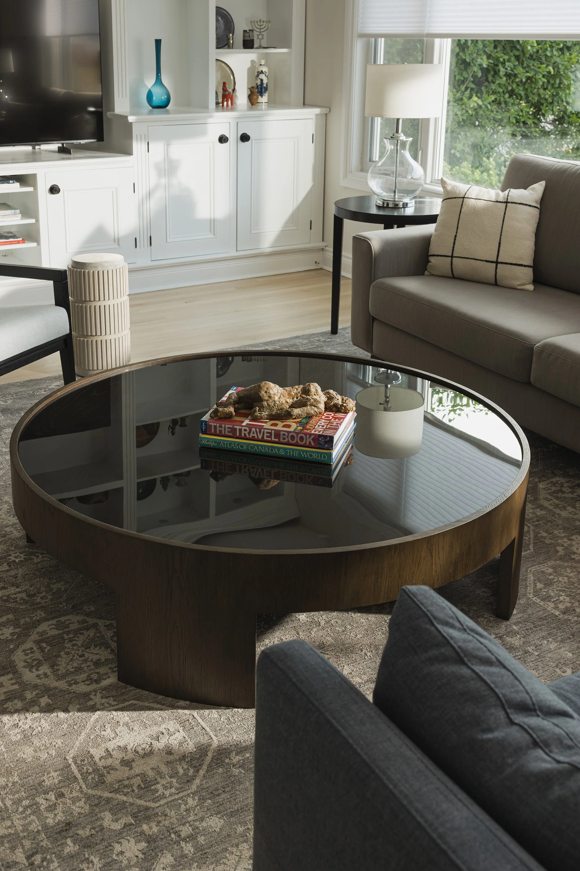 Ottawa interior design featuring a glass and wood round coffee table.